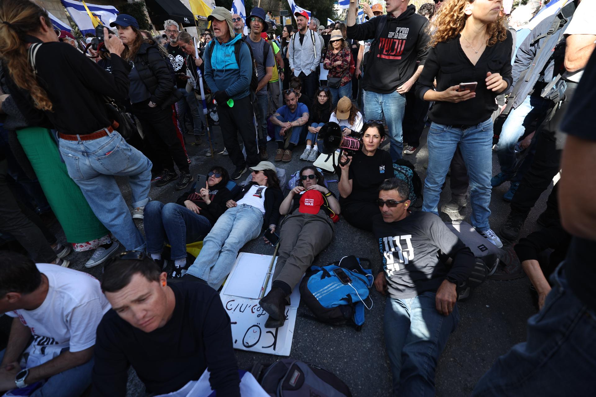 Los manifestantes yacen en la calle durante una marcha para protestar por la reanudación de los combates en Gaza y en contra de los planes anunciados del primer ministro israelí Netanyahu de destituir al jefe del Shin Bet, Ronen Bar, en Jerusalén, 19 de marzo de 2025. (Protestas, Jerusalén) EFE/EPA/ATEF SAFADI