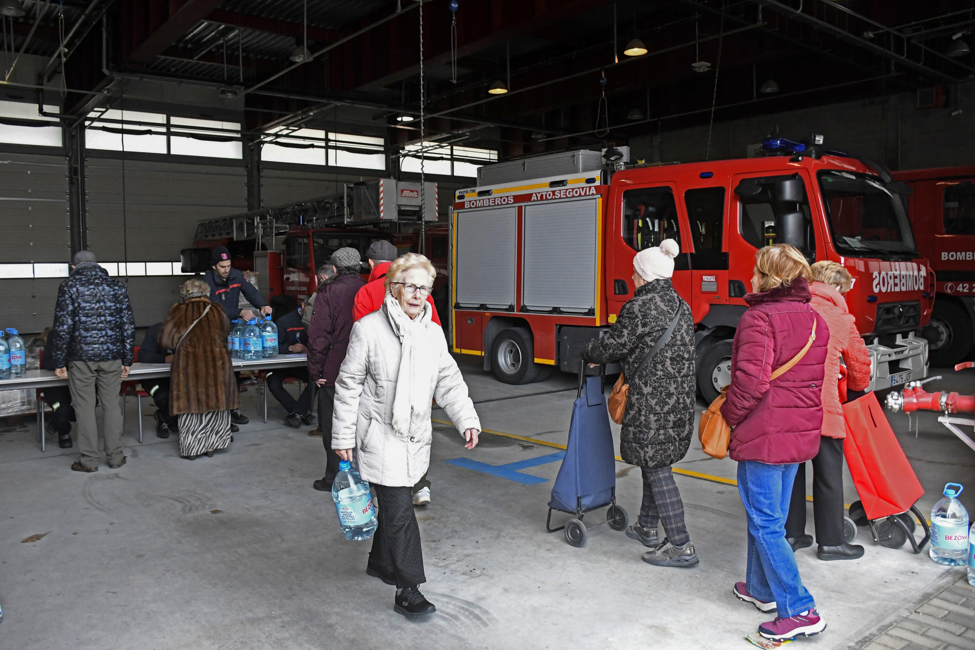 Cerca de 17.000 vecinos de Segovia llevan una semana sin poder consumir agua del grifo por los problemas de turbidez y calidad en el suministro de agua potable originados por el temporal por lo que el Ayuntamiento mantiene el reparto de agua embotellada entre los afectados. La distribución se lleva a cabo en el Parque de Bomberos de la ciudad, según recuerda el Ayuntamiento, que indica que está a la espera de recibir los resultados de los análisis del agua que se realizan con las últimas muestras de agua tomadas durante el fin de semana. En la imagen, reparto de agua a los ciudadanos afectados. EFE/ Pablo Martin
