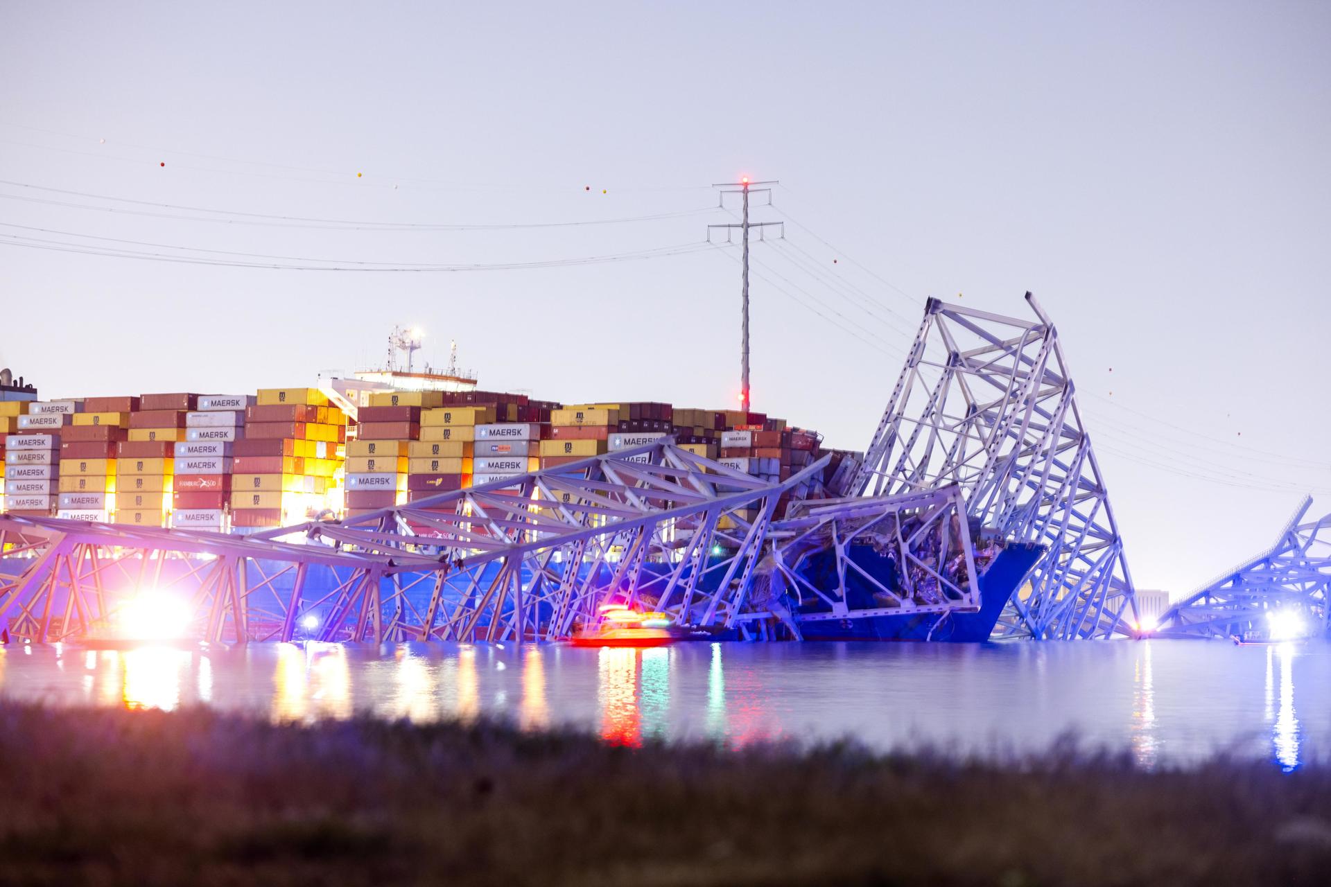 El puente Francis Scott Key yace parcialmente derrumbado después de que un buque portacontenedores chocara contra él en Baltimore, Maryland, el 26 de marzo de 2024. EFE/JIM LO SCALZO