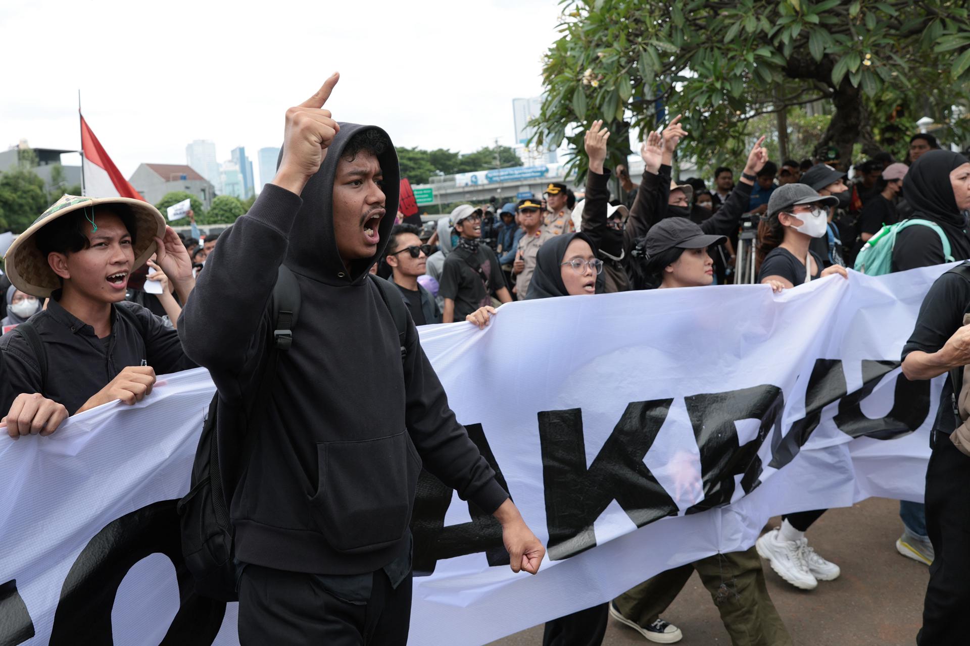JAKARTA (Indonesia), 20/03/2025.- Indonesian student activists carry a banner and shout anti-government slogans during a protest against the revision of the country's military law in front of the Parliament building in Jakarta, Indonesia, 20 March 2025. Indonesia's House of Representatives on 20 March passed a bill revising the Indonesian National Armed Forces (TNI) law that would expand the role of the military, allowing officers to take up civilian posts. (Protestas) EFE/EPA/ADI WEDA
