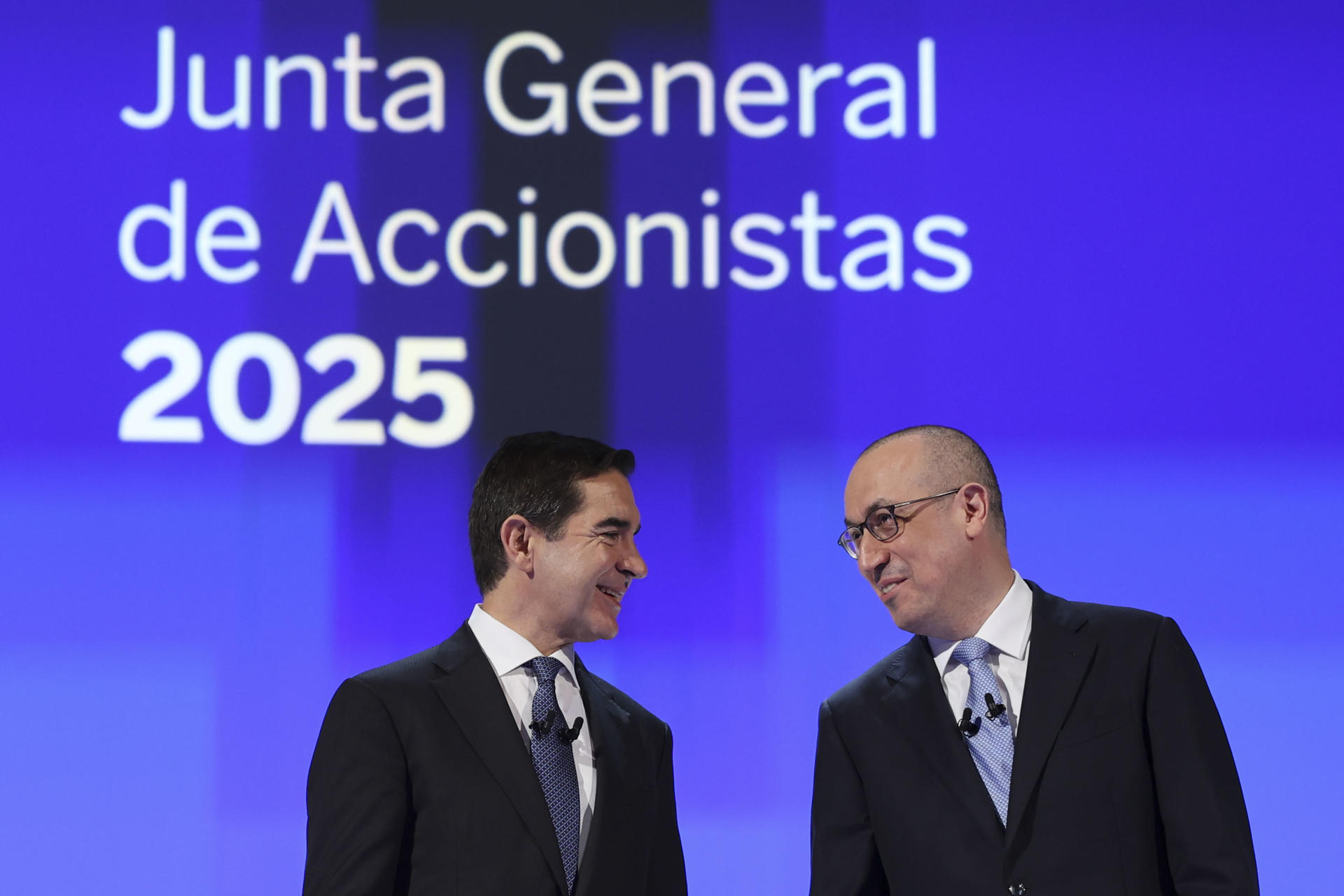 El presidente del BBVA, Carlos Torres Vila, (i) junto al director ejecutivo Onur Genç (d) en la junta donde han afirmado este viernes que la opa de su banco sobre el Sabadell es una "apuesta por España y sus empresas, por crecer y contribuir al crecimiento del país y sus territorios". EFE/Luis Tejido