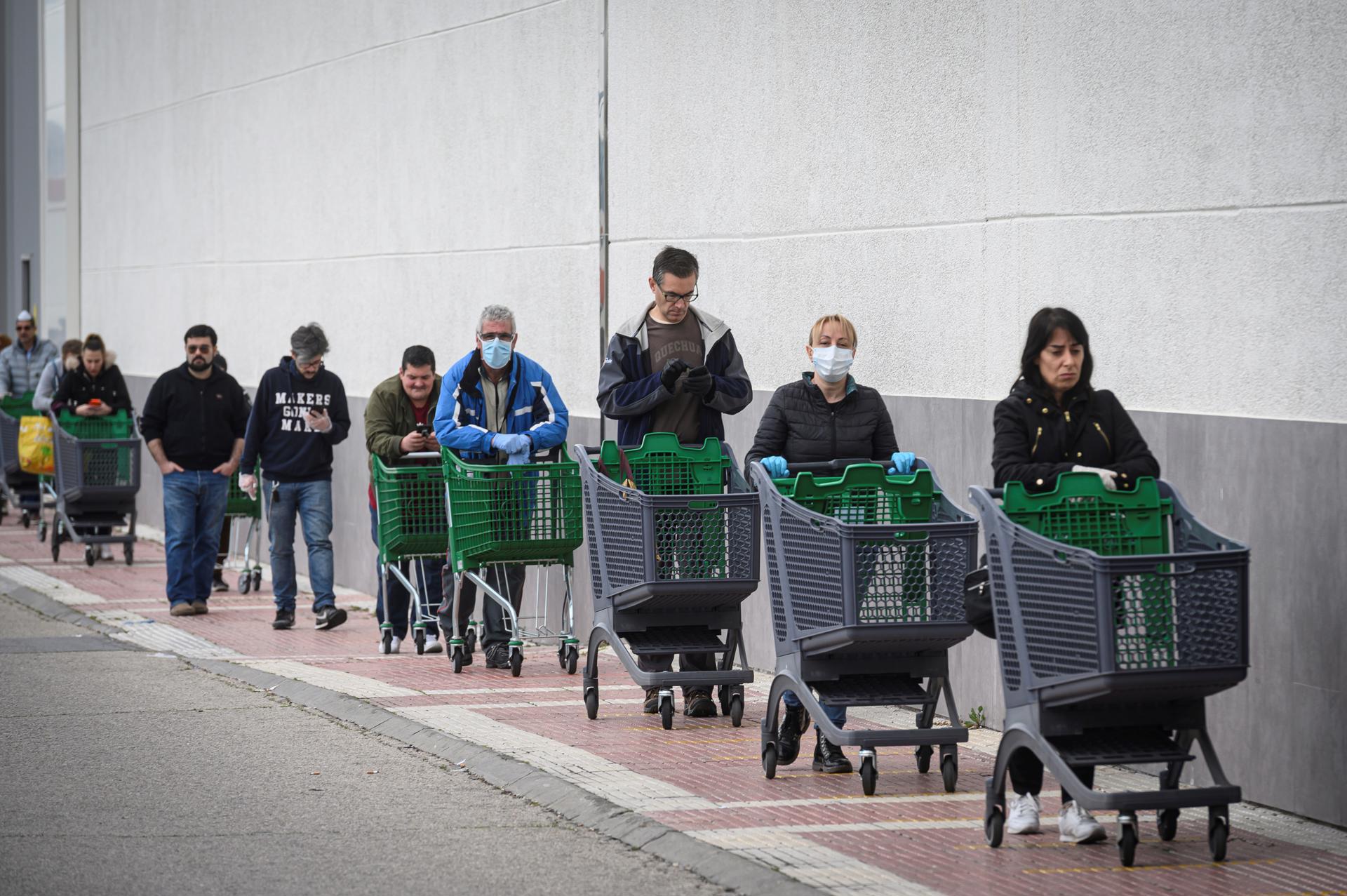 Imagen del 7/4/2020 de varias personas haciendo cola para comprar en un supermercado en Alcalá de Henares (Madrid). EFE/Fernando Villar