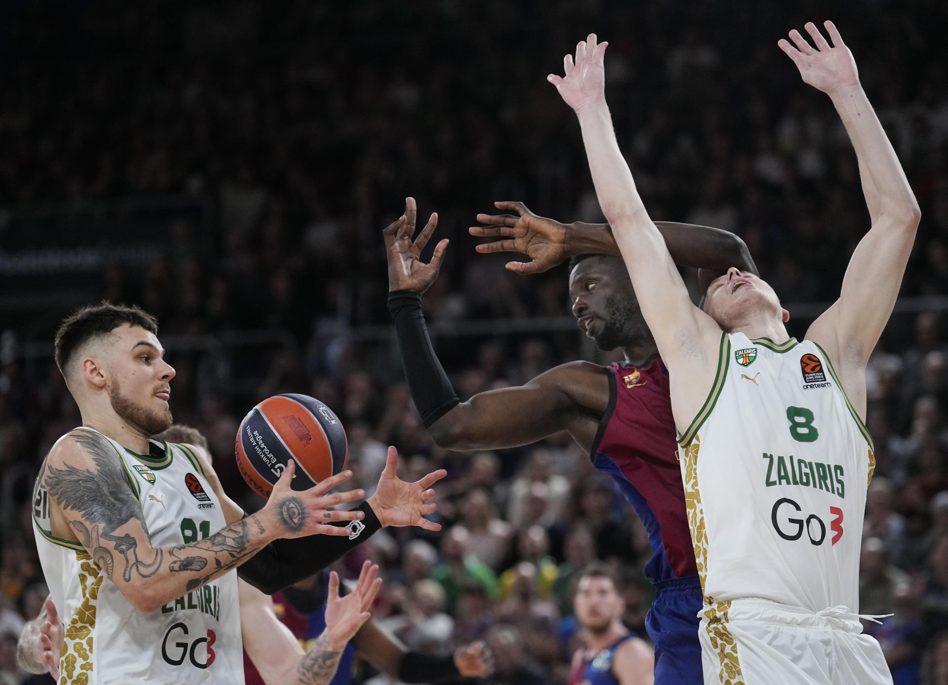 El pívot del Barcelona Youssoupha Fall (c) pelea un balón con Sirvydis (i) y Smailagic, ambos del Zalgiris, durante el partido de la jornada 30 de la EuroLiga que Barça y Zalguiris Kaunas disputan este viernes en el Palau Blaugrana. EFE/Enric Fontcuberta.