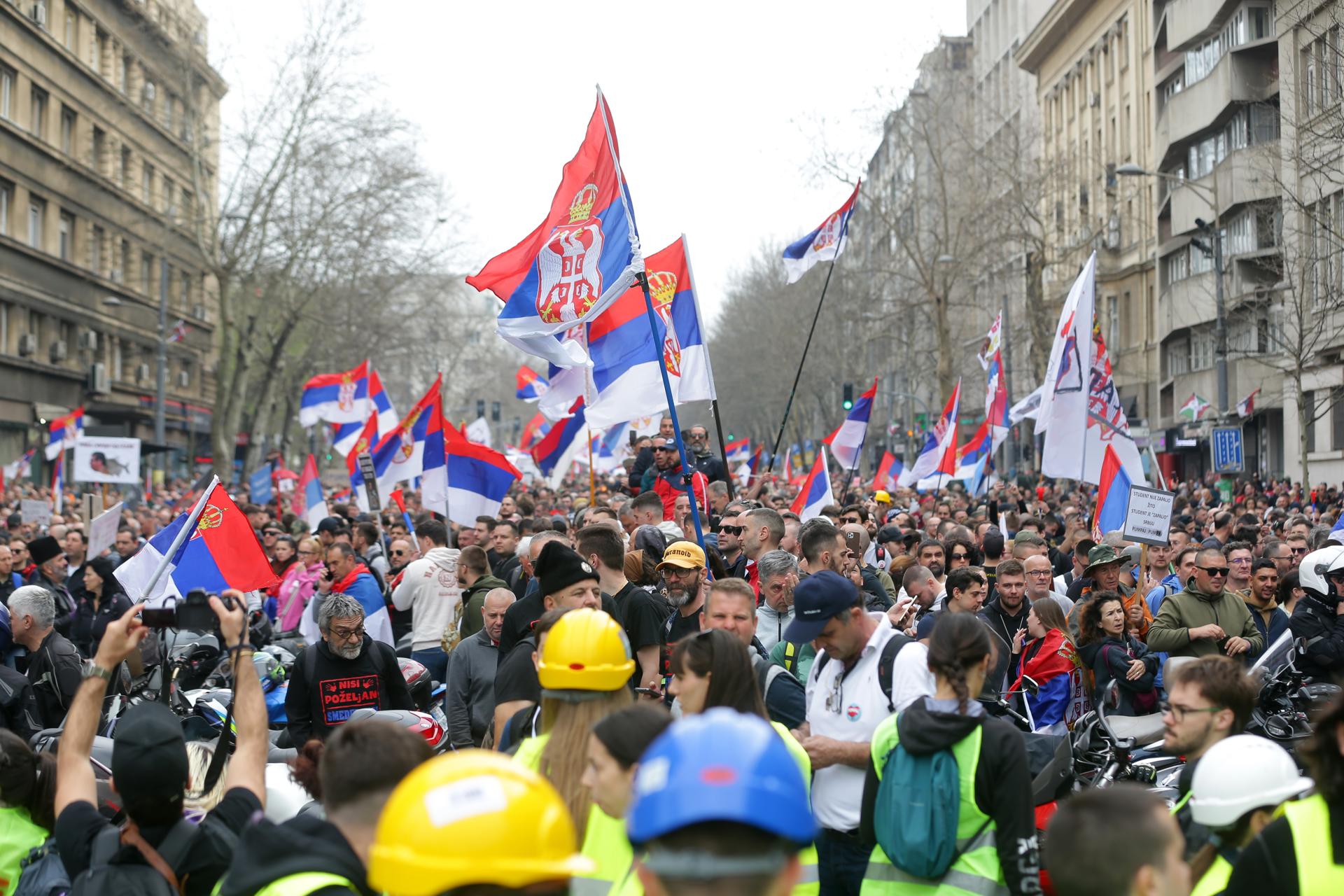 Manifestantes ondean banderas durante la marcha de protesta oragnizada en Belgrado contra el Gobierno serbio. EFE/EPA/Andrej Cukic