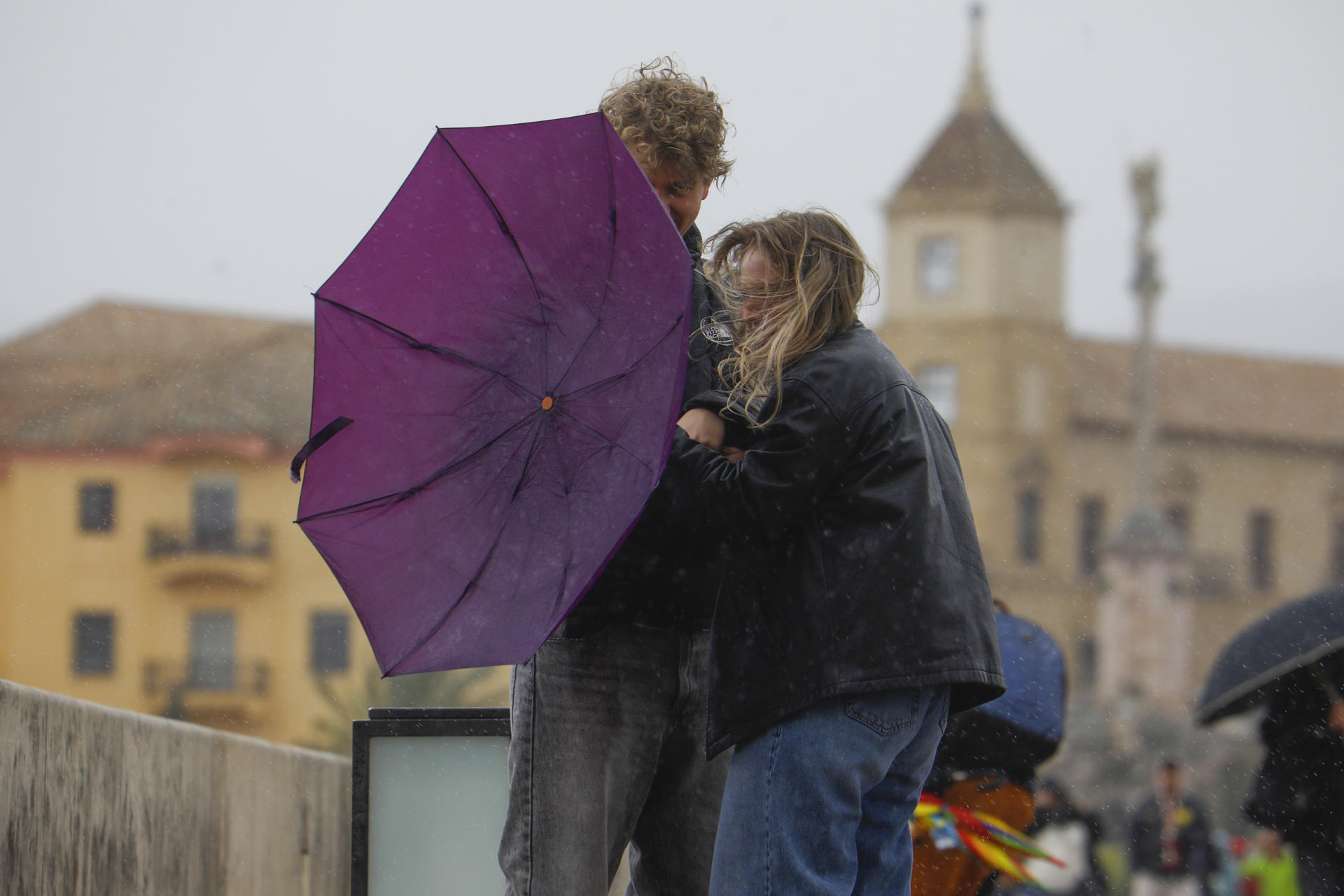 Fotografía de archivo de una pareja que trata de protegerse con un paraguas del temporal de viento y lluvia. EFE/Salas