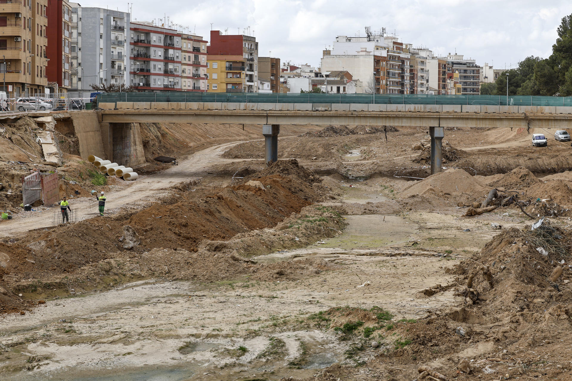 Dos operarios trabajando en el barranco del Poyo a su paso por la Paiporta el pasado 28 de febrero. EFE/Ana Escobar