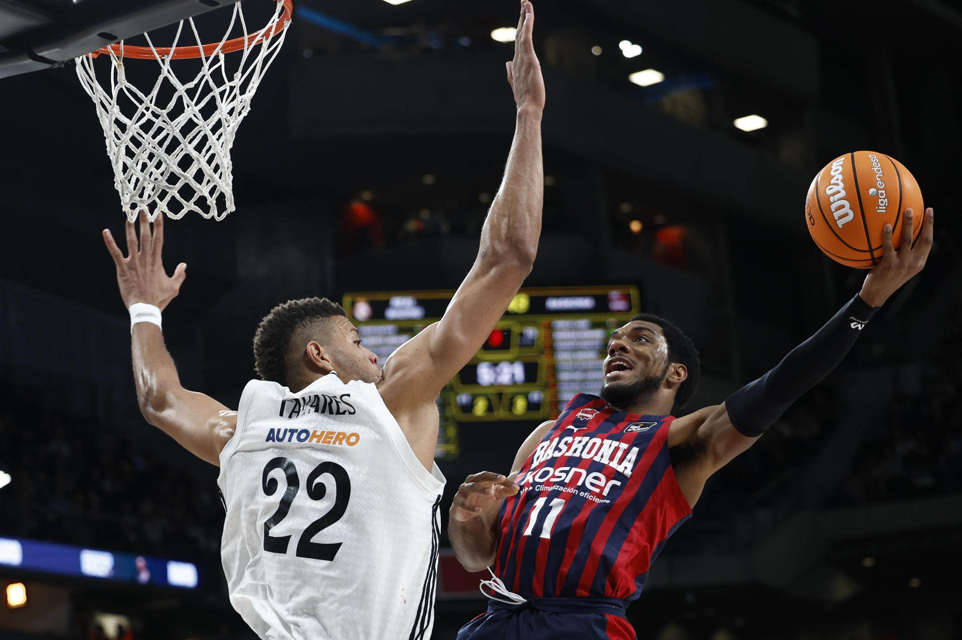 El base estadounidense de Baskonia, Trent Forrest (d), intenta encestar ante el pivot caboverdiano del Real Madrid, Edy Tavares, durante el encuentro correspondiente a la fase regular de la Liga Endesa que disputaron Baskonia y Real Madrid en el pabellón Movistar Arena de Madrid. EFE / Daniel González.