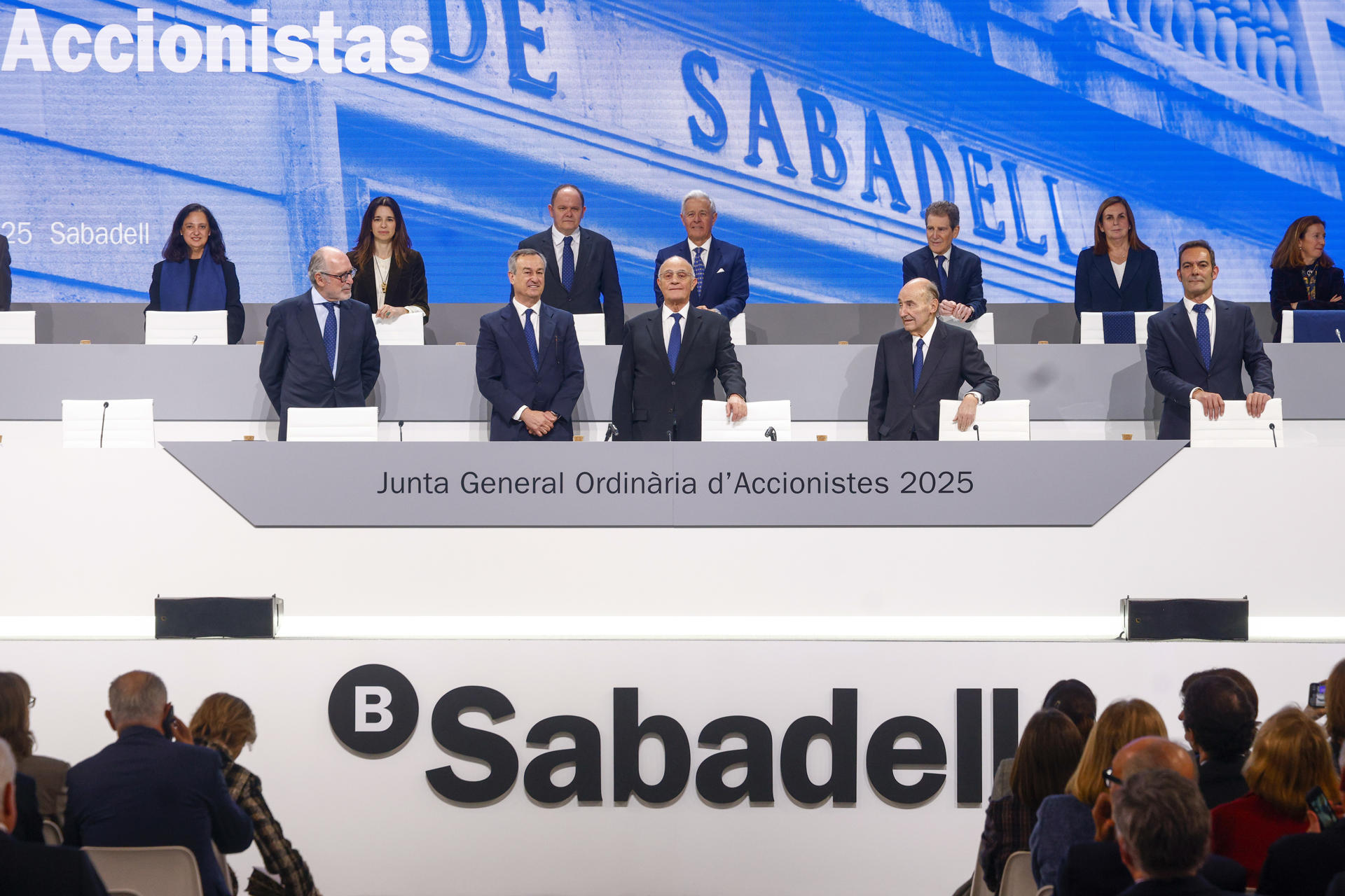 El presidente del Banco Sabadell, Josep Oliu (c) junto al consejero delegado César González-Bueno (2i) , durante la Junta General de Accionistas de la entidad, que se celebra por primera vez en Sabadell (Barcelona) después de que el banco anunciara en enero el retorno de su sede social a Cataluña tras más de siete años en Alicante desde donde ha alertado este jueves de los "riesgos de ejecución" de la opa lanzada por el BBVA ante sus accionistas, que le han dedicado una larga ovación, y ha apelado al "bien común de este país" a la hora de valorar la oferta. EFE/ Quique García
