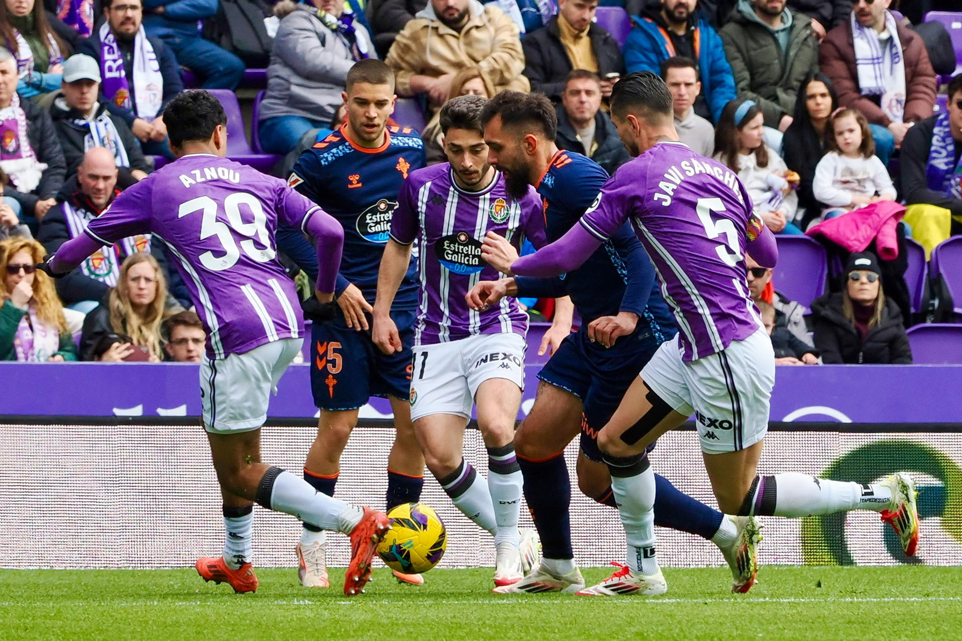 El delantero del Celta de Vigo, Borja Iglesias (c) ante la presión del defensa Javi Sánchez (d) del Real Valladolid durante el partido de Primera División disputado en el estadio José Zorrilla este sábado. EFE/R.García
