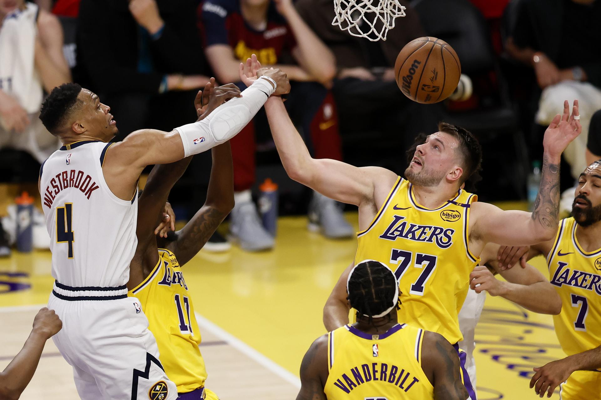 El escolta de Los Angeles Lakers Luka Doncic (d) bloquea un tiro del escolta de los Denver Nuggets Russell Westbrook (i) durante el primer cuarto del partido de baloncesto de la NBA entre los Denver Nuggets y Los Angeles Lakers en Los Ángeles, California (EE.UU.). EFE/CAROLINE BREHMAN PROHIBIDO SU USO EN SHUTTERSTOCK