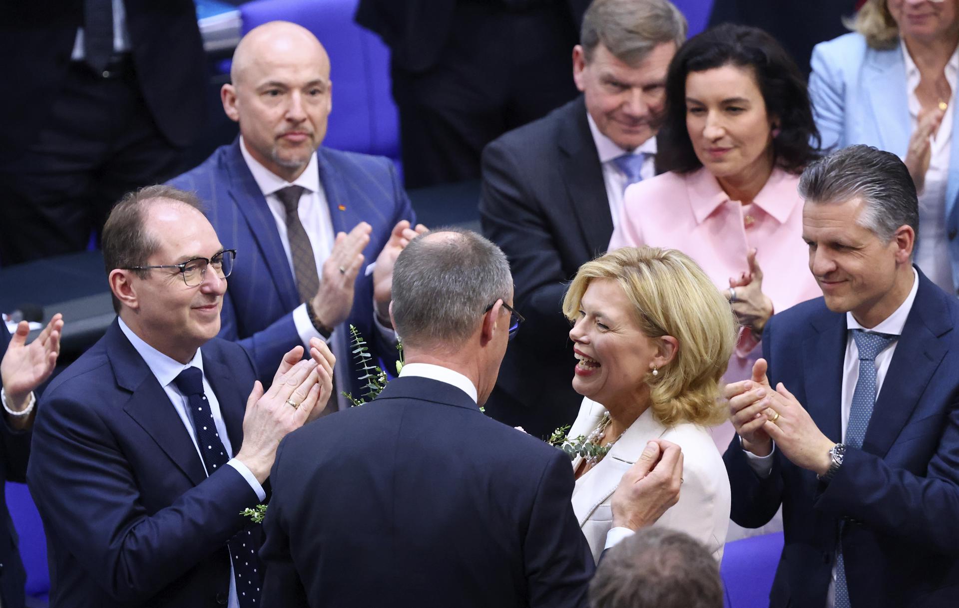 La recién elegida presidenta del Bundestag, Julia Kloeckner (C-D), recibe flores del presidente del partido y de la facción de la Unión Demócrata Cristiana (CDU), Friedrich Merz (C-I), durante la sesión constitutiva del parlamento alemán 'Bundestag', en Berlín, Alemania, 25 de marzo de 2025. El 21º Bundestag alemán celebra su primera sesión constitutiva tras las elecciones generales del 23 de febrero. (Elections, Germany) EFE/EPA/HANNIBAL HANSCHKE
