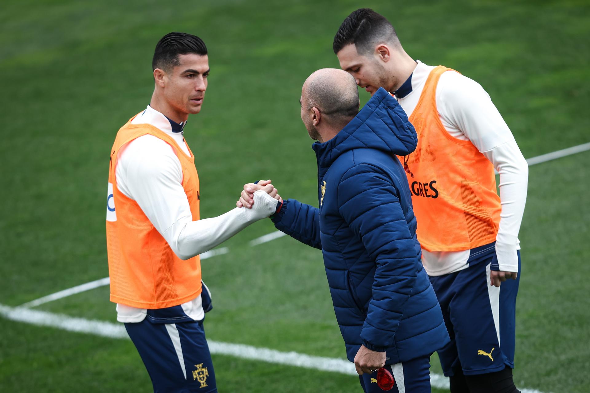El seleccionador de Portugal Roberto Martinez (C) saluda a Cristiano Ronaldo y Diogo Dalot durante el entrenamiento de este miércoles. EFE/EPA/RODRIGO ANTUNES
