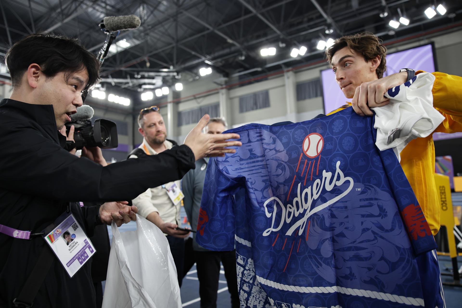 El sueco Armand Duplantis recibe una camiseta de los Dodgers tras la rueda de prensa previa al Campeonayo del Mundo bajo techo de Nanjing. EFE/ANDRES MARTINEZ CASARES
