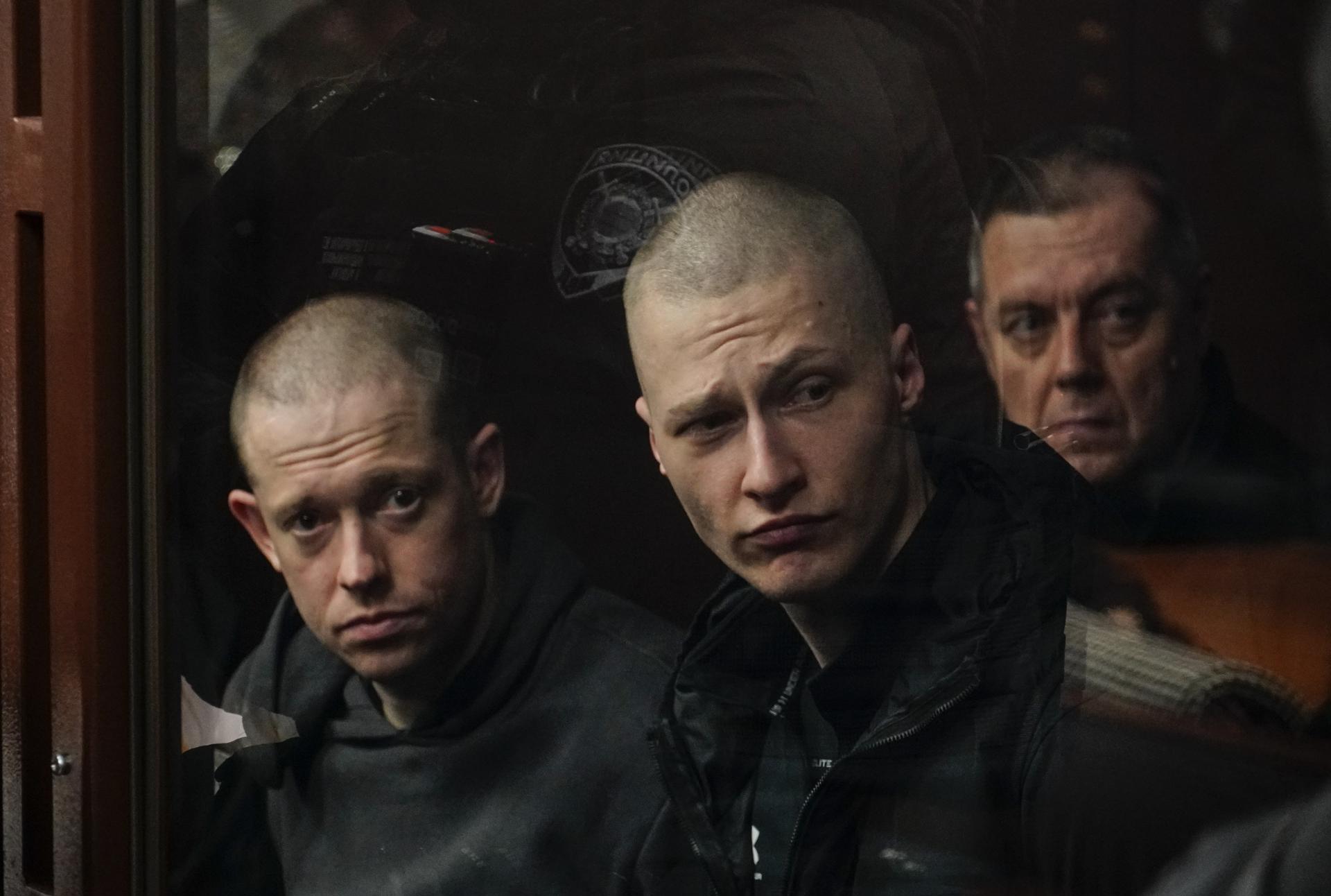 Rostov del Don (Federación Rusa), 26/03/2025.- Prisioneros de guerra ucranianos del batallón ultranacionalista "Azov" se sientan en la celda de los acusados ​​durante una audiencia en el Tribunal Militar del Distrito Sur de Rostov del Don, Rusia, este miércoles. El tribunal dictó veredictos de culpabilidad contra miembros de la brigada ucraniana "Azov", un grupo designado como organización terrorista y prohibido en Rusia. EFE/ Stringer