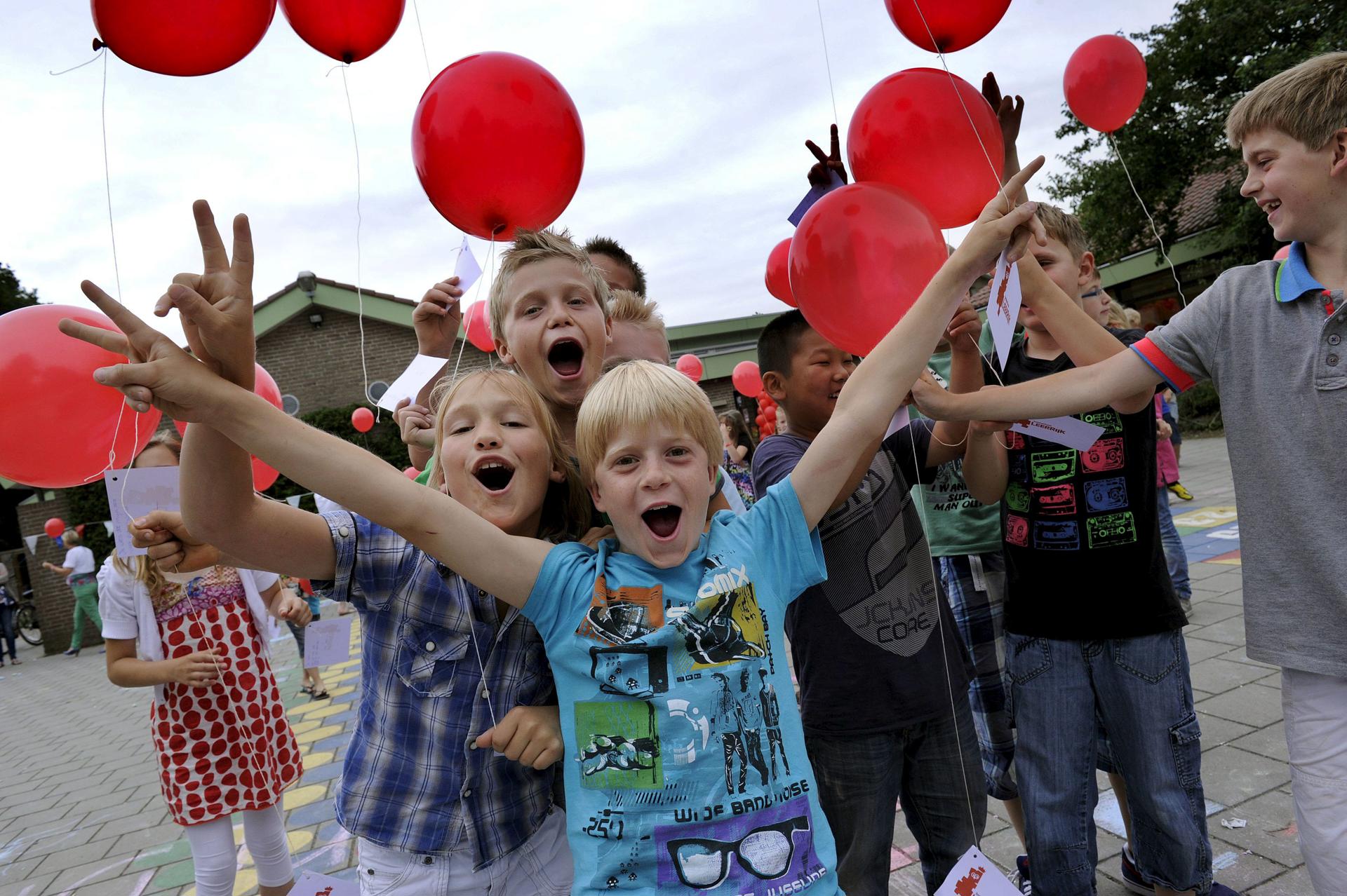Un grupo de niños con globos celebraban el comienzo de las vacaciones de verano en la escuela Leerrijk en Someren, Holanda, en junio de 2012. EFE/Ed Oudenaarden/Archivo.