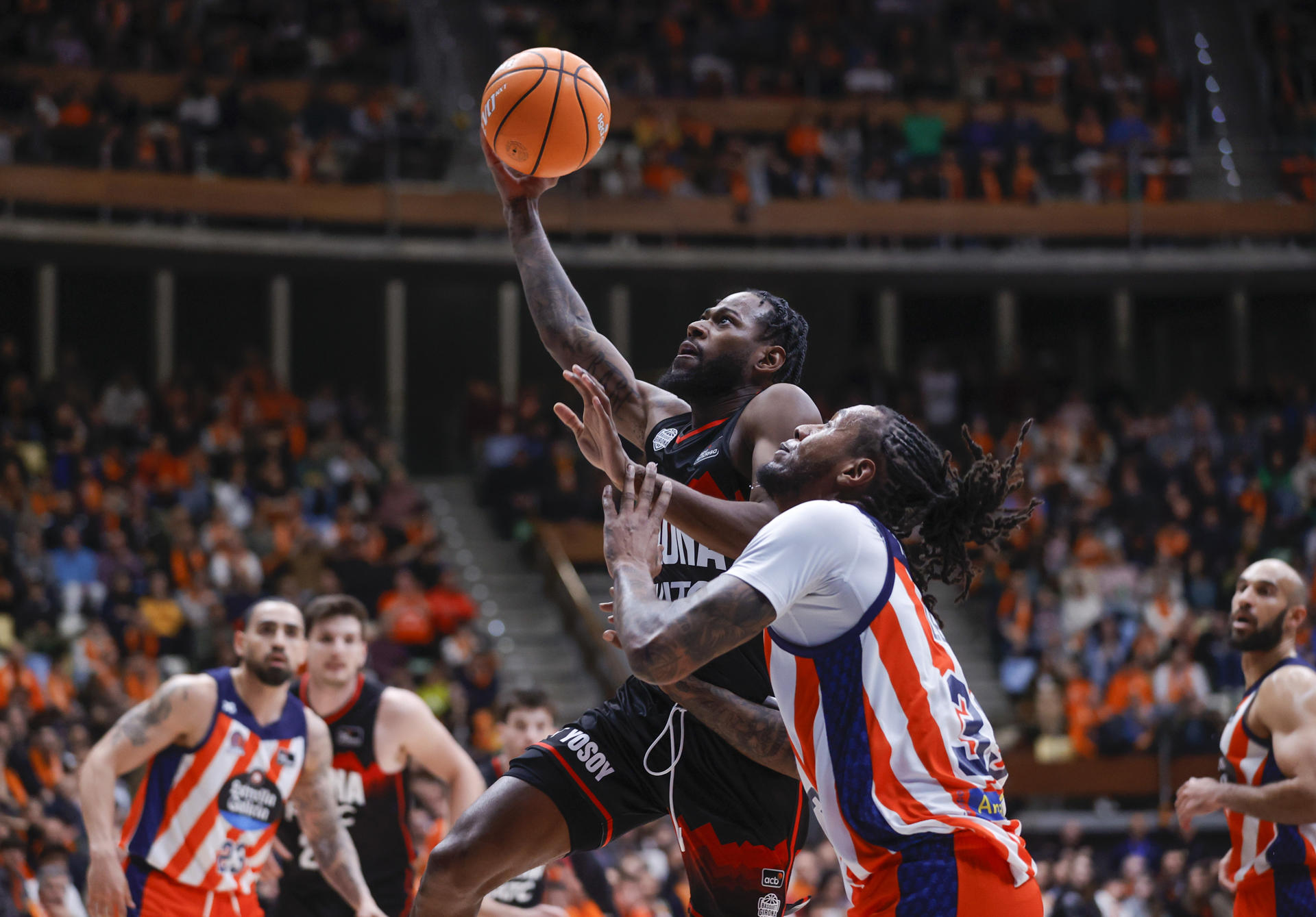 El base estadounidense del Básquet Girona, Aljami Durham (i) entra a canasta ante el ala-pívot estadounidense del Leyma Básquet Coruña, Trey Thompkins, durante el partido de la jornada 25 de la Liga Endesa que Leyma Básquet Coruña y Básquet Girona en el Coliseum de A Coruña.- EFE/ Cabalar