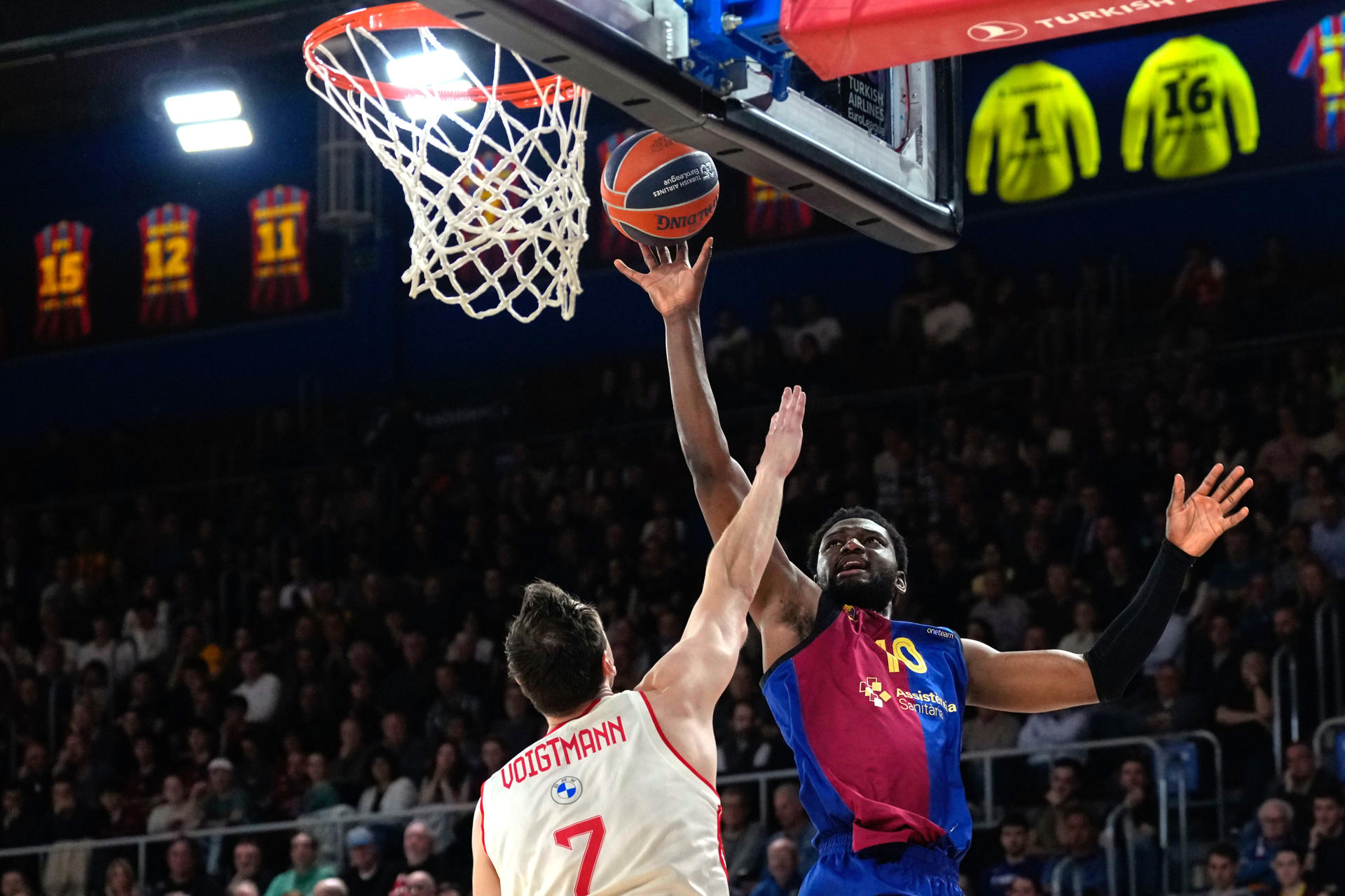 El ala-pívot del Barça Chimezie Metu (d) lanza a canasta ante Johannes Voigtmann, del Bayern, durante el partido de la jornada 31 de la EuroLiga que Barça y Bayern de Múnich disputan en el Palau Blaugrana. EFE/Alejandro García
