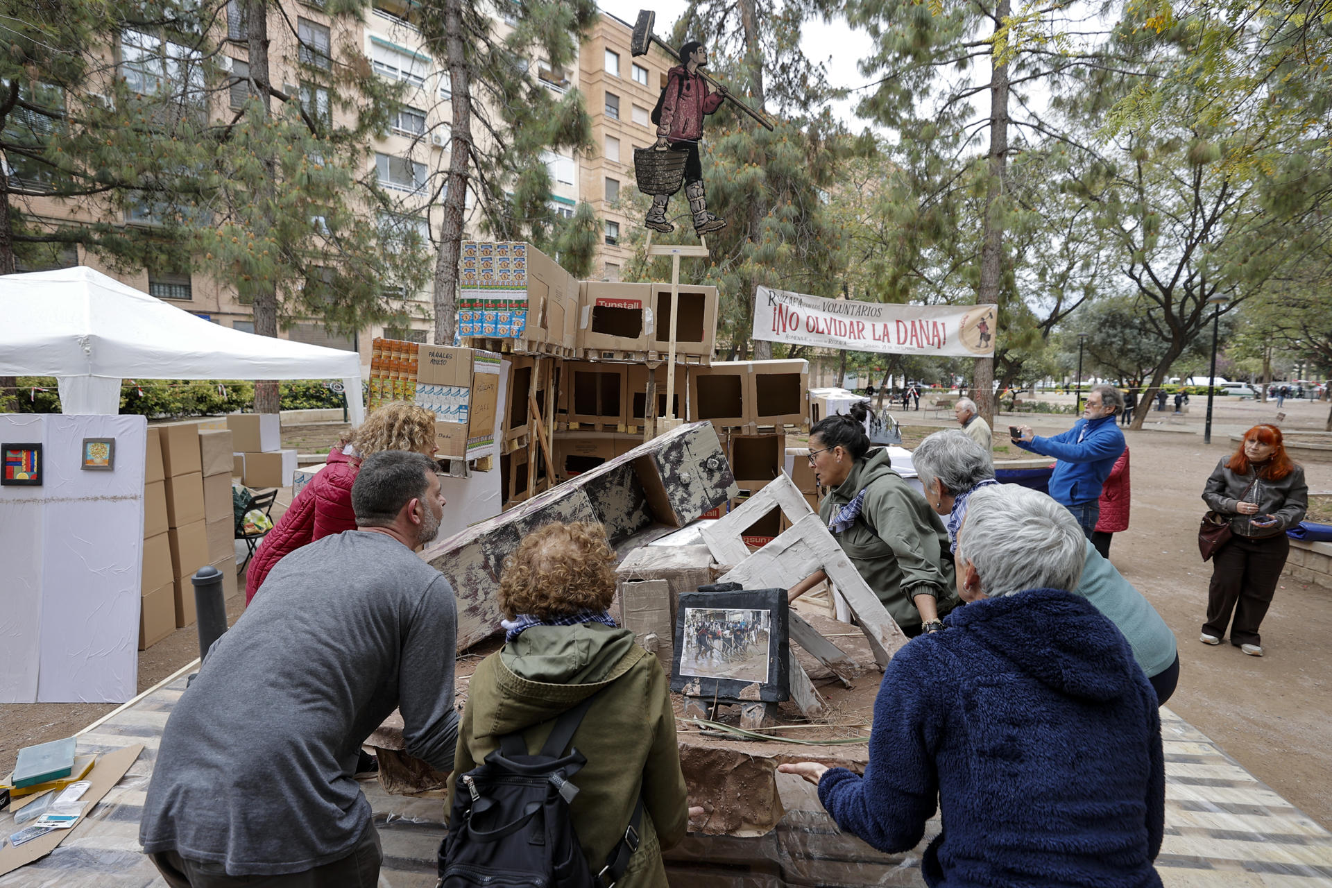Varios miembros del Centro de Voluntarios ‘La Cantina’ montan la falla ‘No olvidar la DANA’ en el Parque Manuel Granero del barrio de Russafa durante este domingo en el que ya se encuentran montados todos los monumentos falleros. EFE/Manuel Bruque