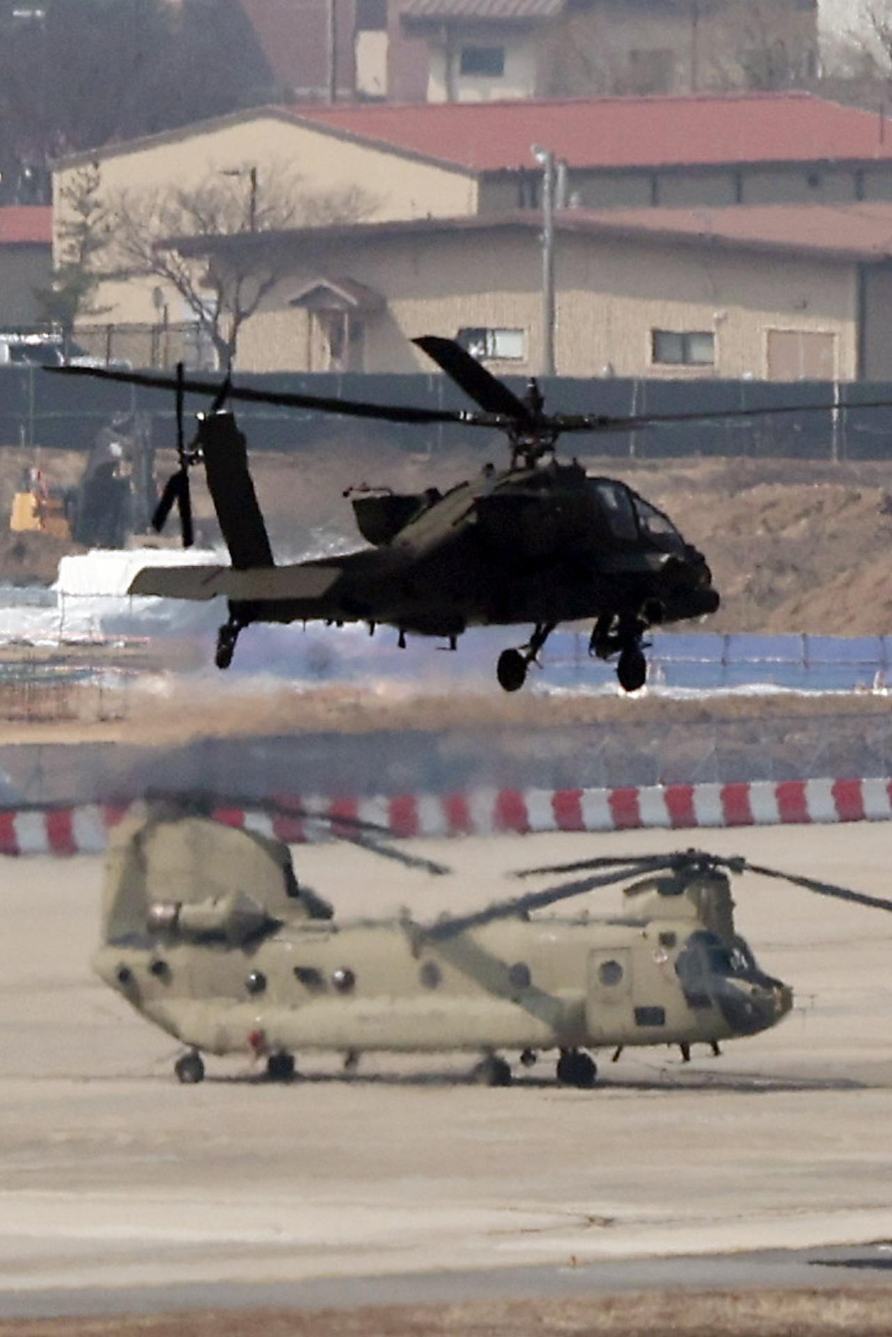 Un helicóptero Apache en vuelo y un Chinook en tierra en la base Humphreys de EE.UU. en Pyeongtaek, Corea del Sur, durante los ejercicios Freedom Shield que iniciaron este lunes Seúl y Washington. EFE/EPA/YONHAP SOUTH KOREA OUT
