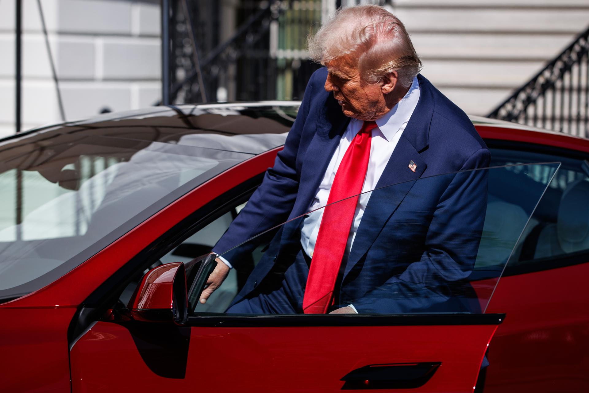 El presidente de Estados Unidos, Donald Trump, sibéndose a un Tesla en la Casa Blanca. EFE/EPA/SAMUEL CORUM