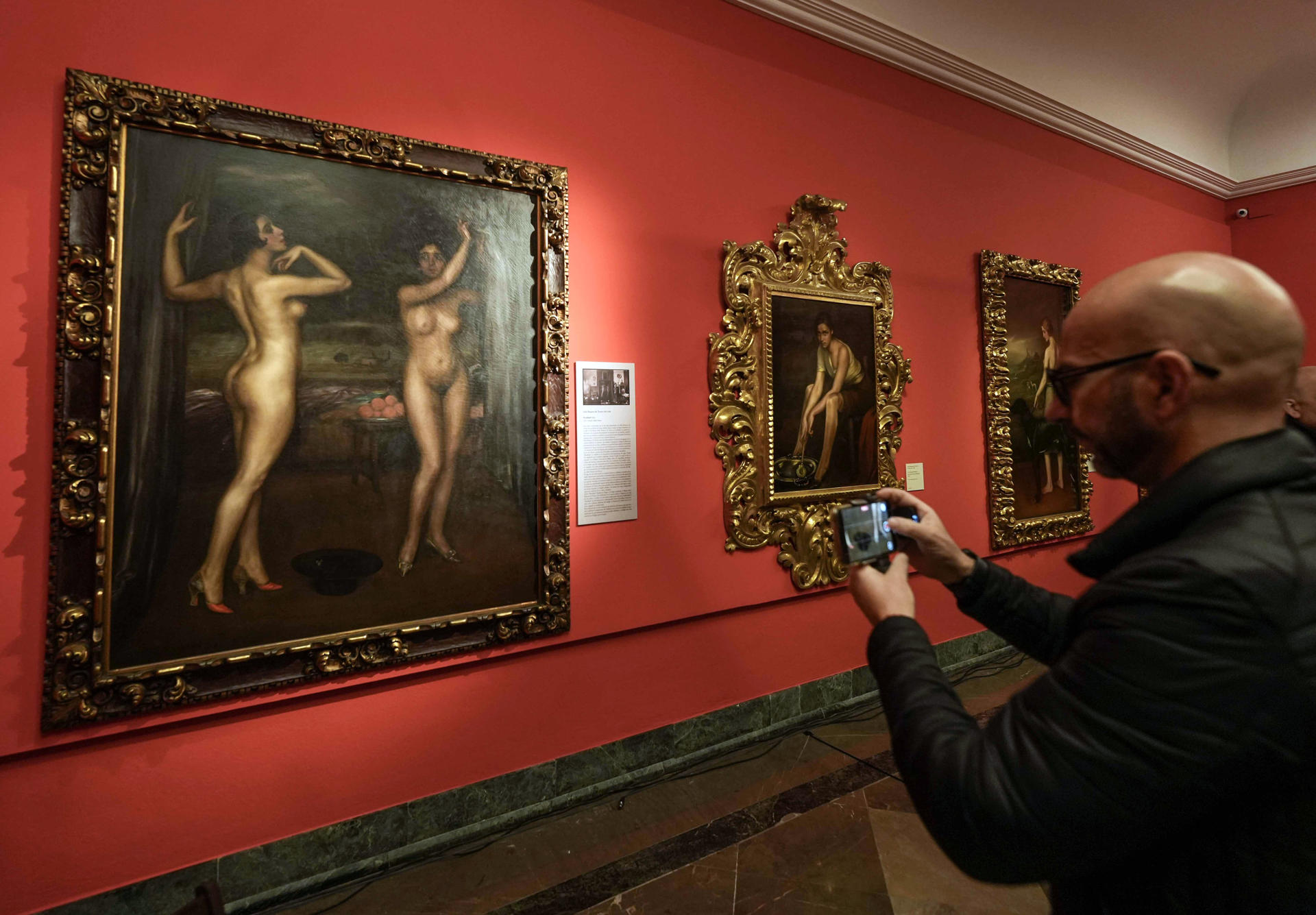 Una persona toma una foto del cuadro 'Rivalidad' (i) del pintor Julio Romero de Torres adquirido por el Ayuntamiento de Córdoba a la Fundación Prasa, la primera obra del artista cordobés comprada por la ciudad en 25 años y que puede verse en el museo que lleva su nombre desde este martes. EFE / Rafa Alcaide
