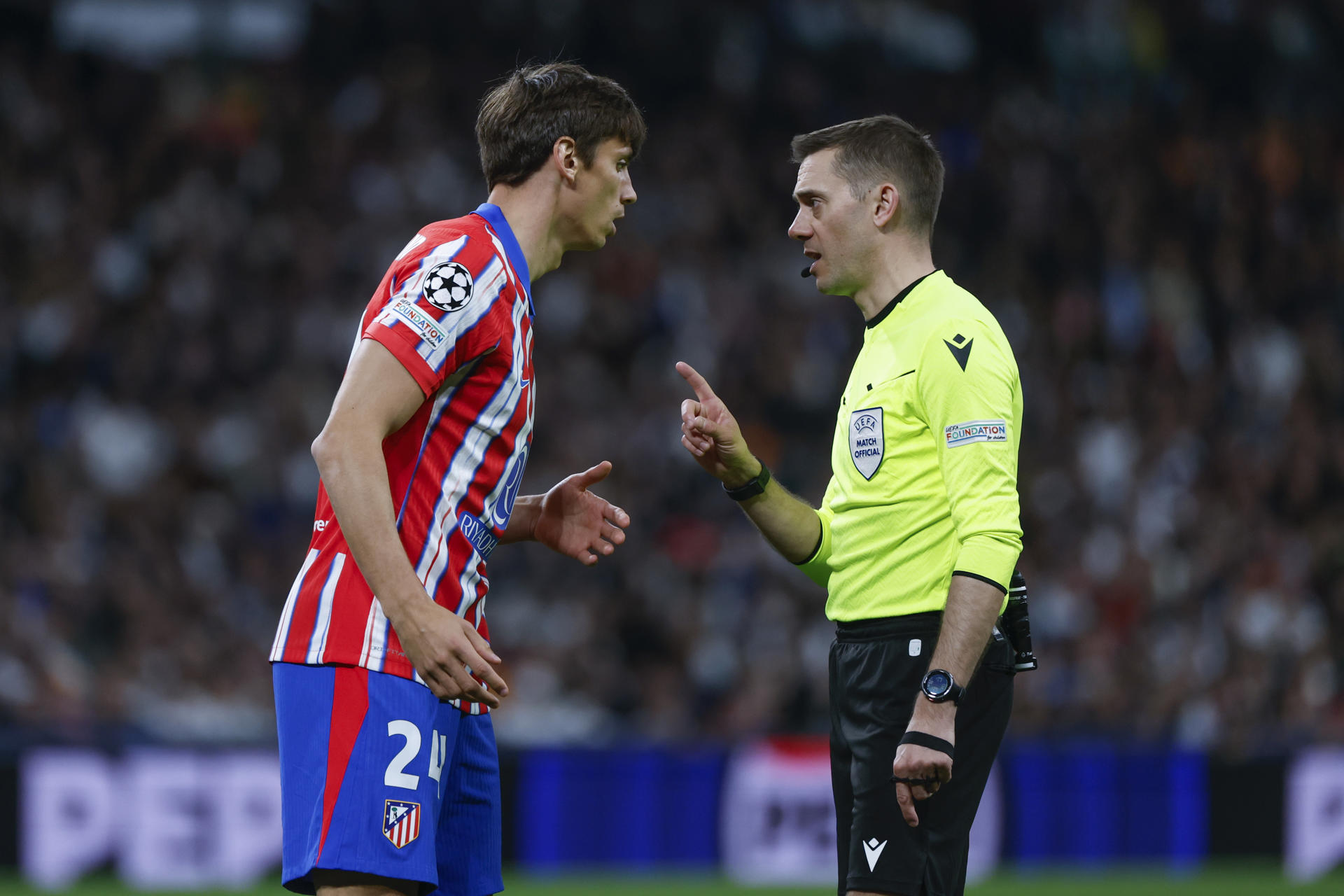 El árbitro francés Clement Turpin, que dirigirá la vuelta de octavos entre el Athletic y el Roma, conversa con el defensa Robin Le Normand, en el partido de ida de octavos de la Liga de Campeones que disputaron la semana pasada el Real Madrid y el Atlético. EFE / Juanjo Martín.
