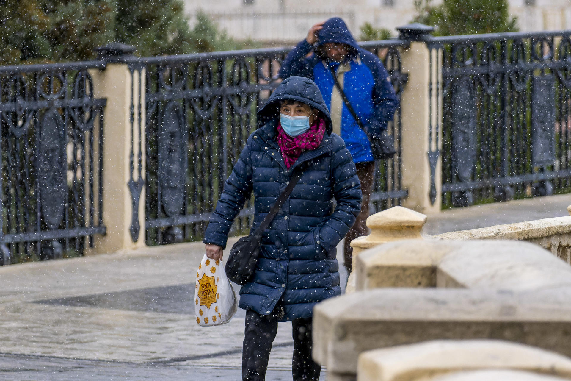 Un mujer camina bajo una ligera nevada esta mañana en Teruel. La Agencia Estatal de Meteorología (Aemet) mantiene activada este viernes la alerta amarilla por acumuaciones de nieve en 24 horas en el Pirineo y la provincia de Teruel. EFE/Antonio Garcia