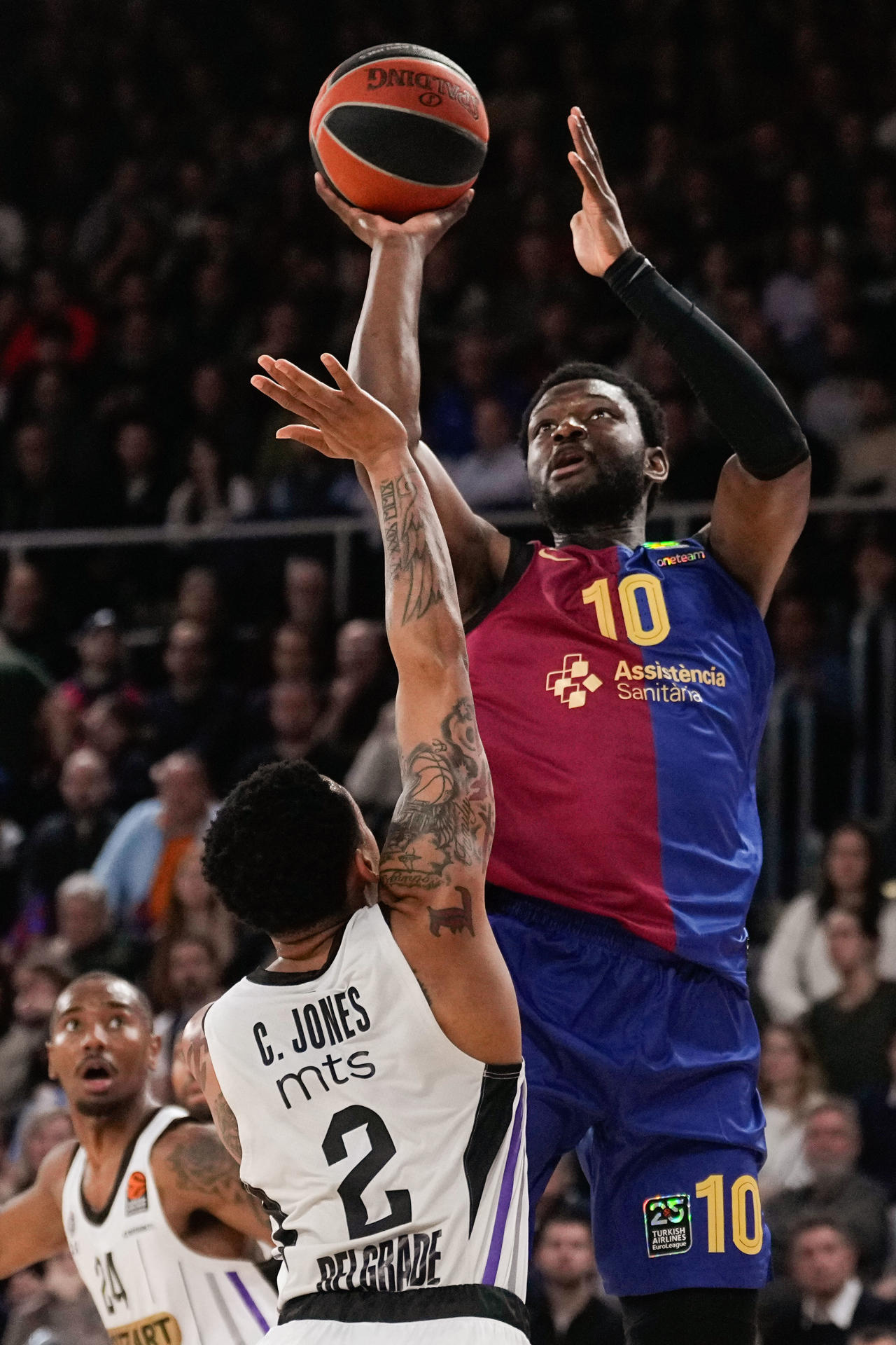 El pivot nigeriano del FC Barcelona Chimezie Metu (d) lanza ante el balón ante el base estadounidense del Partizan Carlik Jones durante el encuentro correspondiente a la fase regular de la Euroliga que disputan hoy viernes FC Barcelona y Partizan en el Palau Blaugrana. EFE/ Enric Fontcuberta.