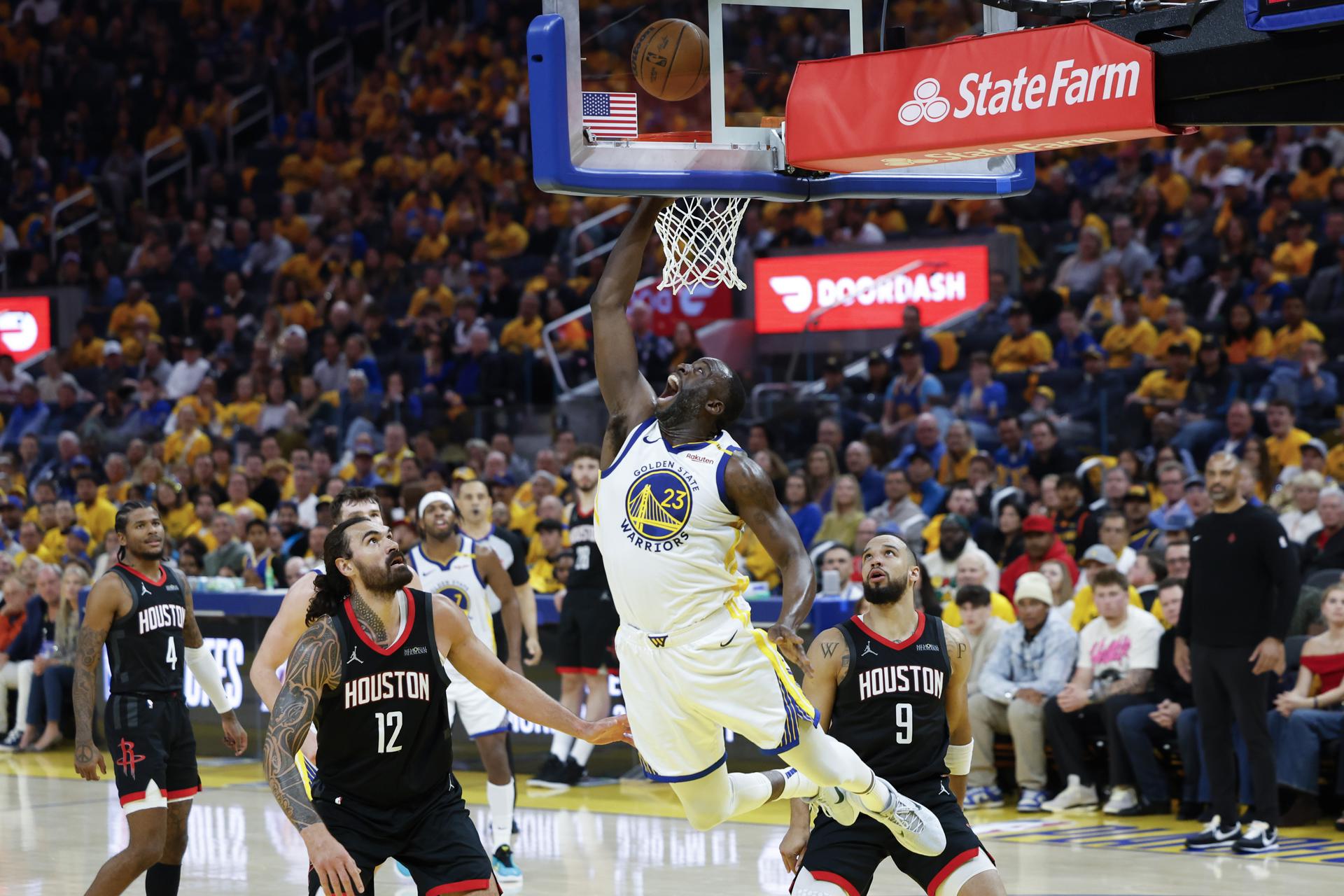 El ala-pívot de Golden State Warriors, Draymond Green (C), supera este sábado a sus custodios para anotar dos puntos durante el tercer juego de la primera ronda de 'playoffs' de la Conferencia Oeste de la NBA contra Houston Rockets en San Francisco. EFE/EPA/JOHN G. MABANGLO