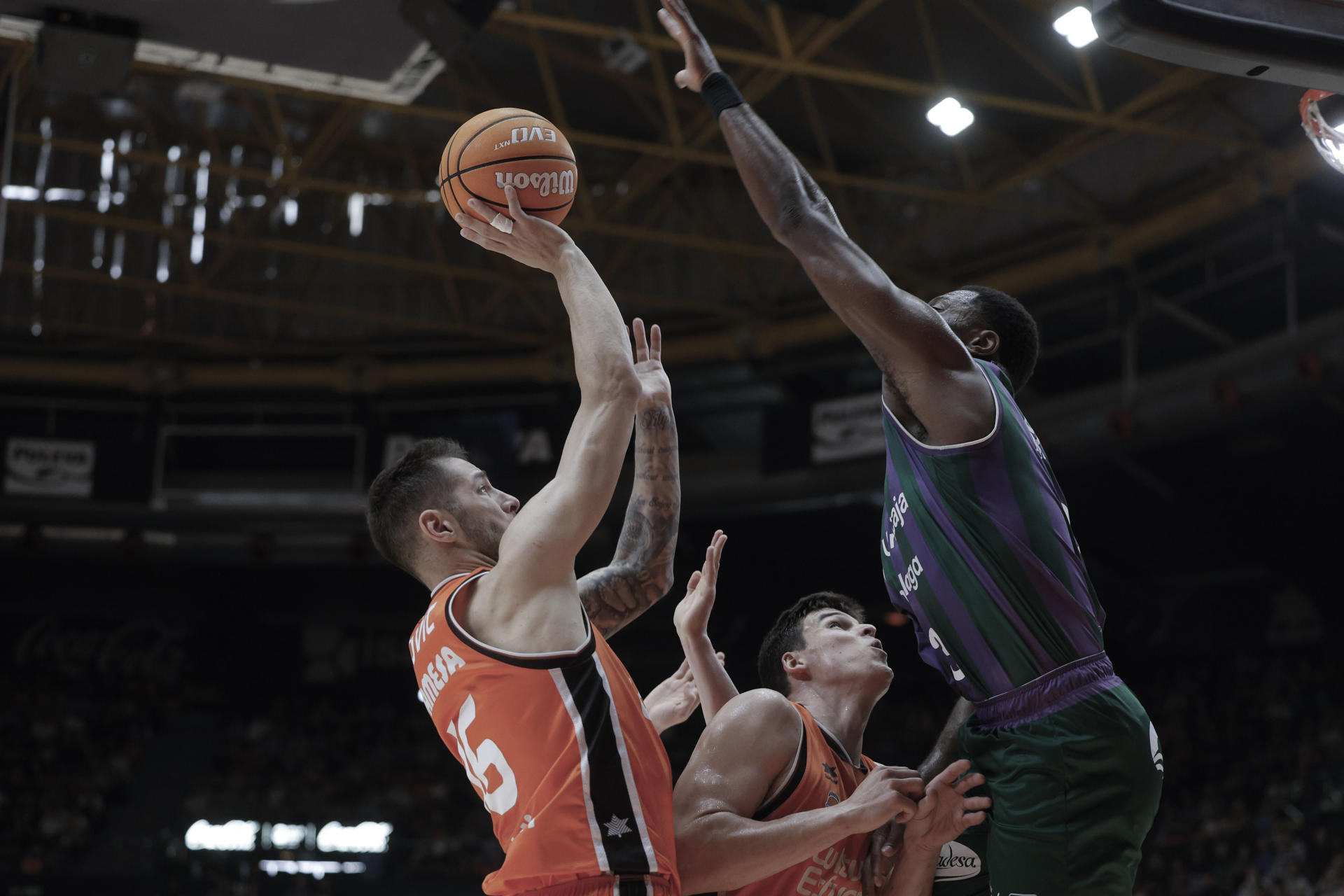 El base servio del Valencia Stefan Jovic (i) lanza a canasta durante el partido de la Liga Endesa de baloncesto que Valencia Basket y Unicaja disputaron en el Pabellón Municipal Fuente de San Luis. EFE/Kai Forsterling