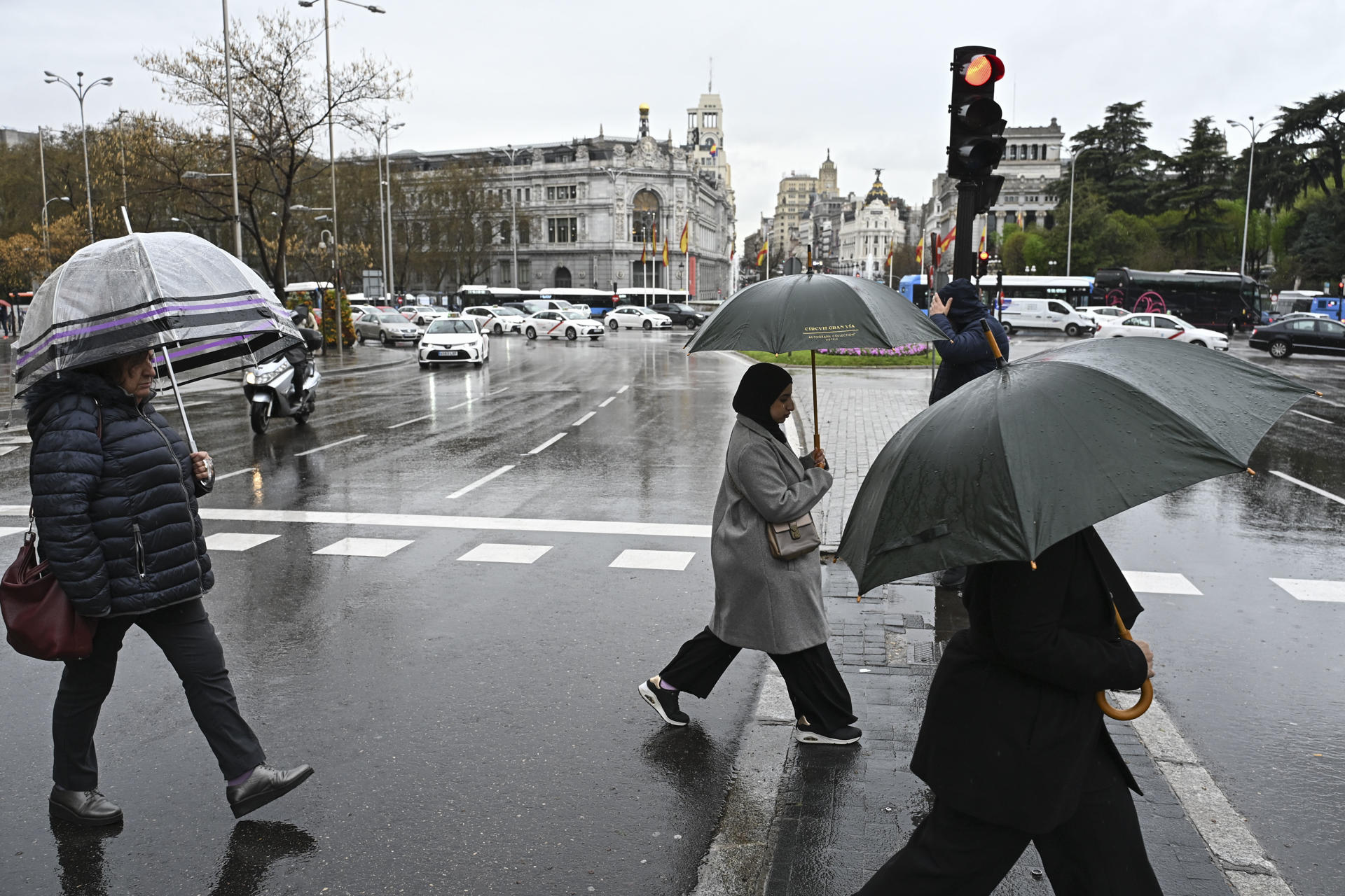 Un grupo de personas camina con sus paraguas en Madrid, en una fotografía de archivo. EFE/ Fernando Villar