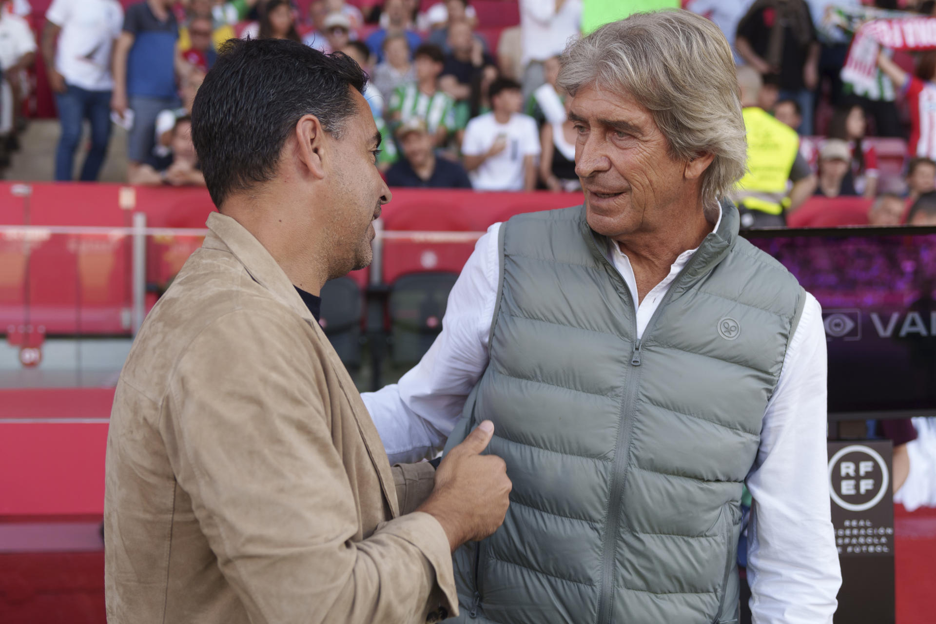El técnico del Girona, Michel (i) saluda al del Betis, el chileno Manuel Pellegrini. EFE / Siu Wu.