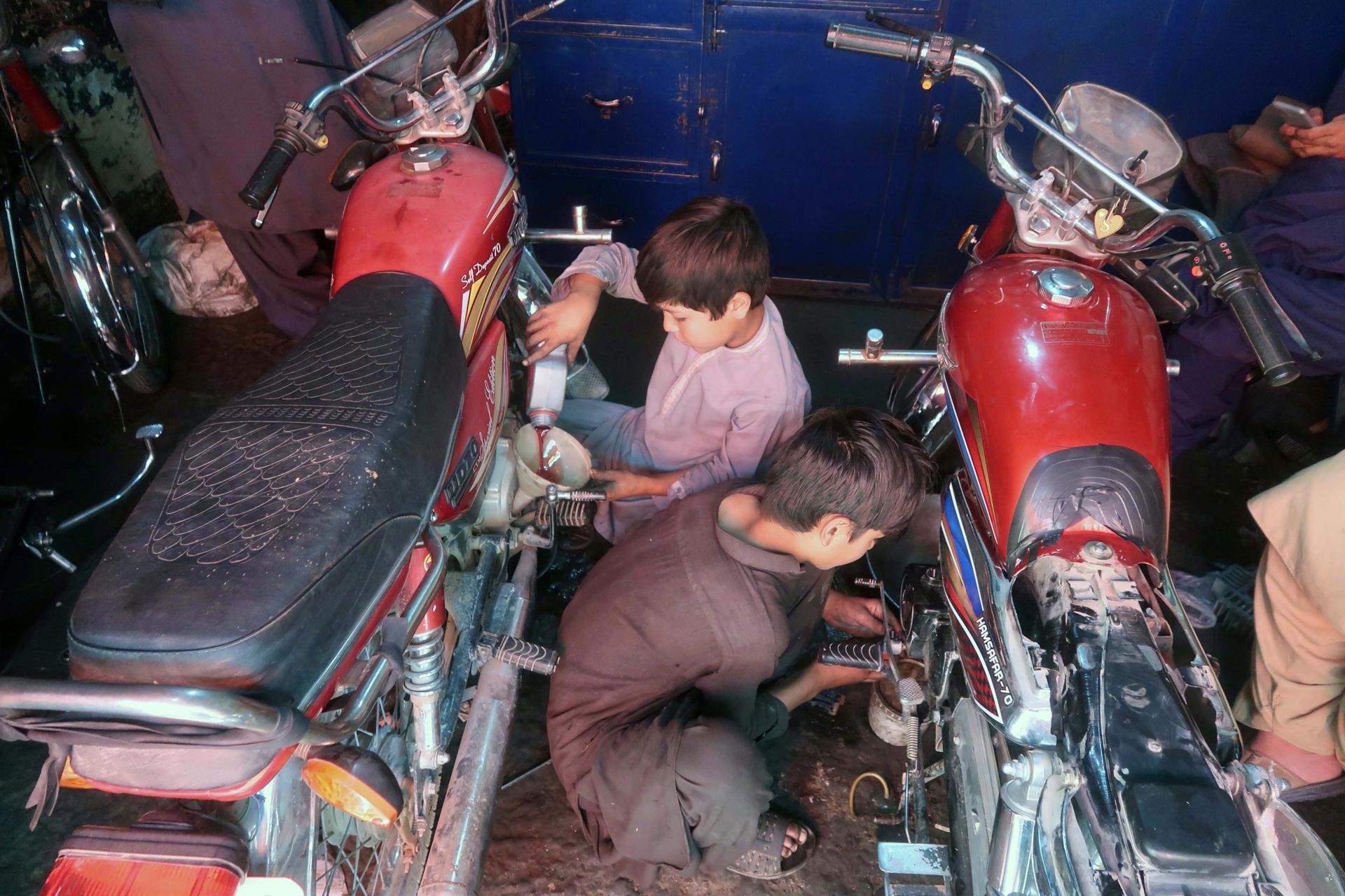Foto de archivo de unos niños paquistaníes trabajando en una tienda de motos en Quetta, Pakistán. EFE/EPA/FAYYAZ AHMAD