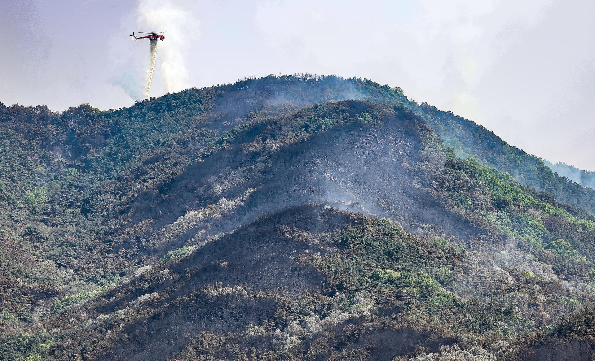 Un helicóptero de extinción de incendios arroja agua sobre el monte Hamji tras un incendio forestal que se desató el día anterior en la ciudad suroriental de Daegu, Corea del Sur, el 29 de abril de 2025. EFE/EPA/YONHAP SOUTH KOREA OUT