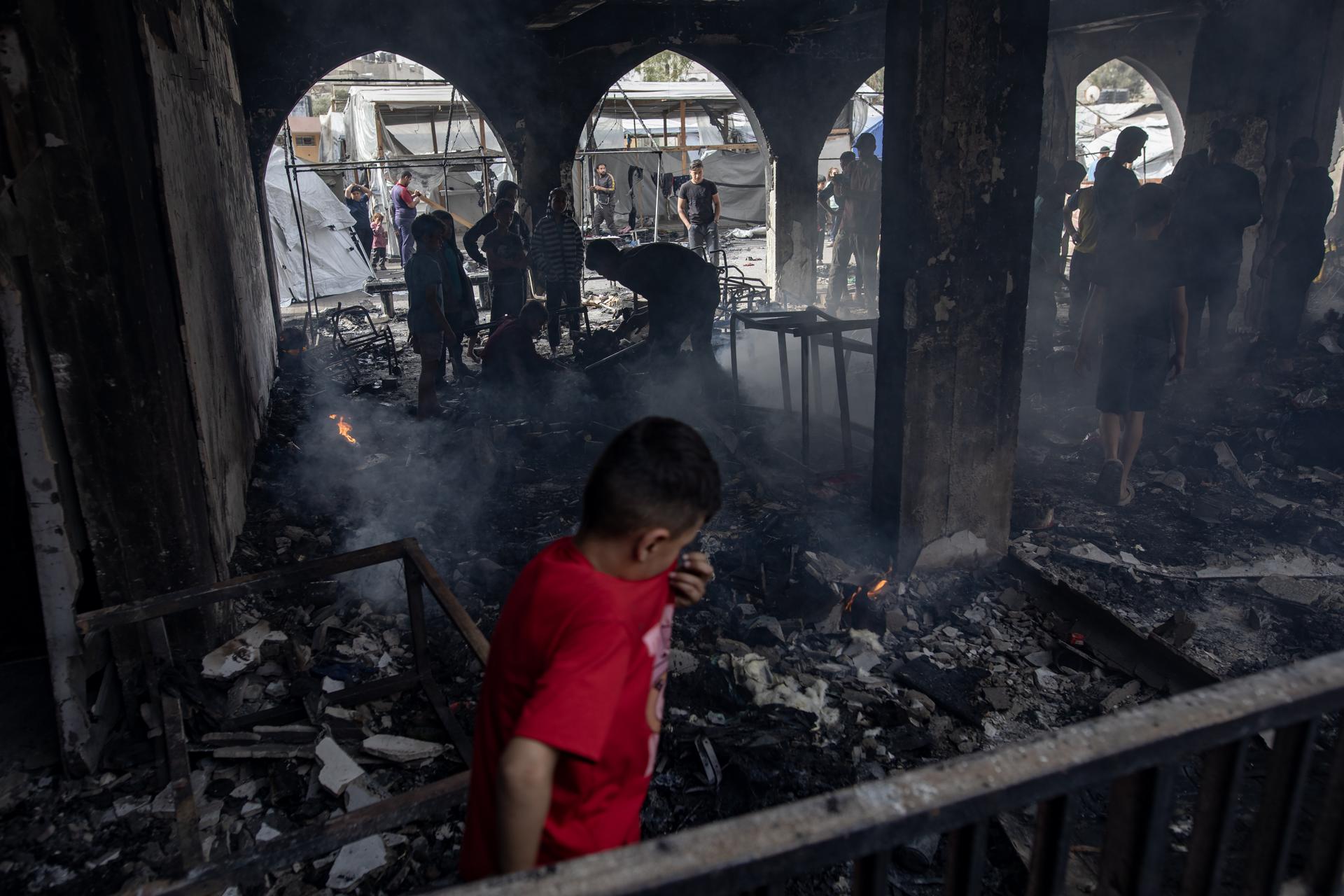 Palestinos desplazados inspeccionan los daños sufridos en la escuela de Yaffa tras un ataque aéreo israelí, al este de la ciudad de Gaza, este miércoles. EFE/ Haitham Imad