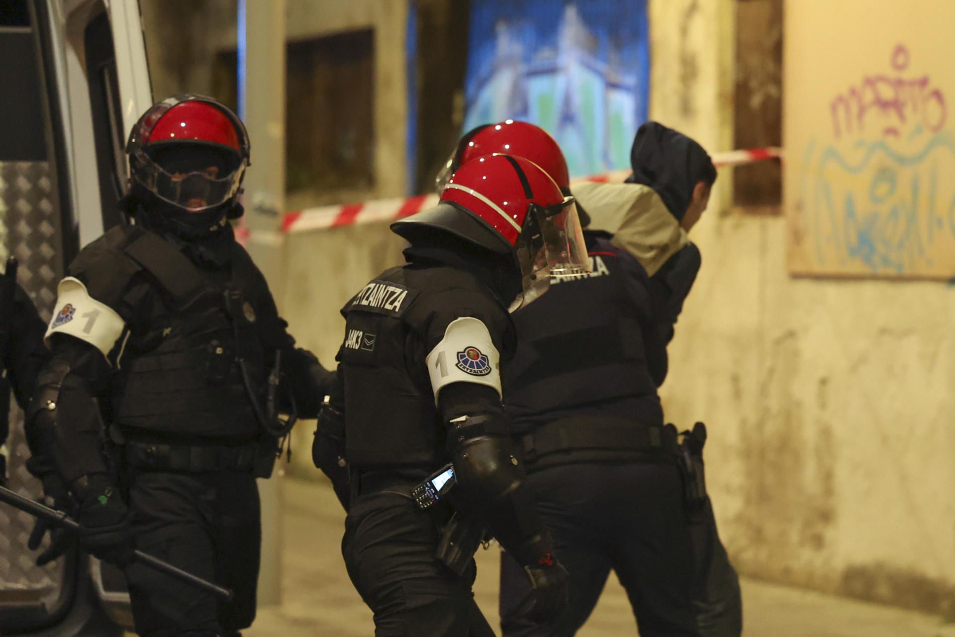 - Miembros de la ertzaina detienen a uno de los manifestantes en el operativo para el desalojo del gaztexe, este jueves en el barrio bilbaíno de Rekalde. EFE/Luis Tejido
