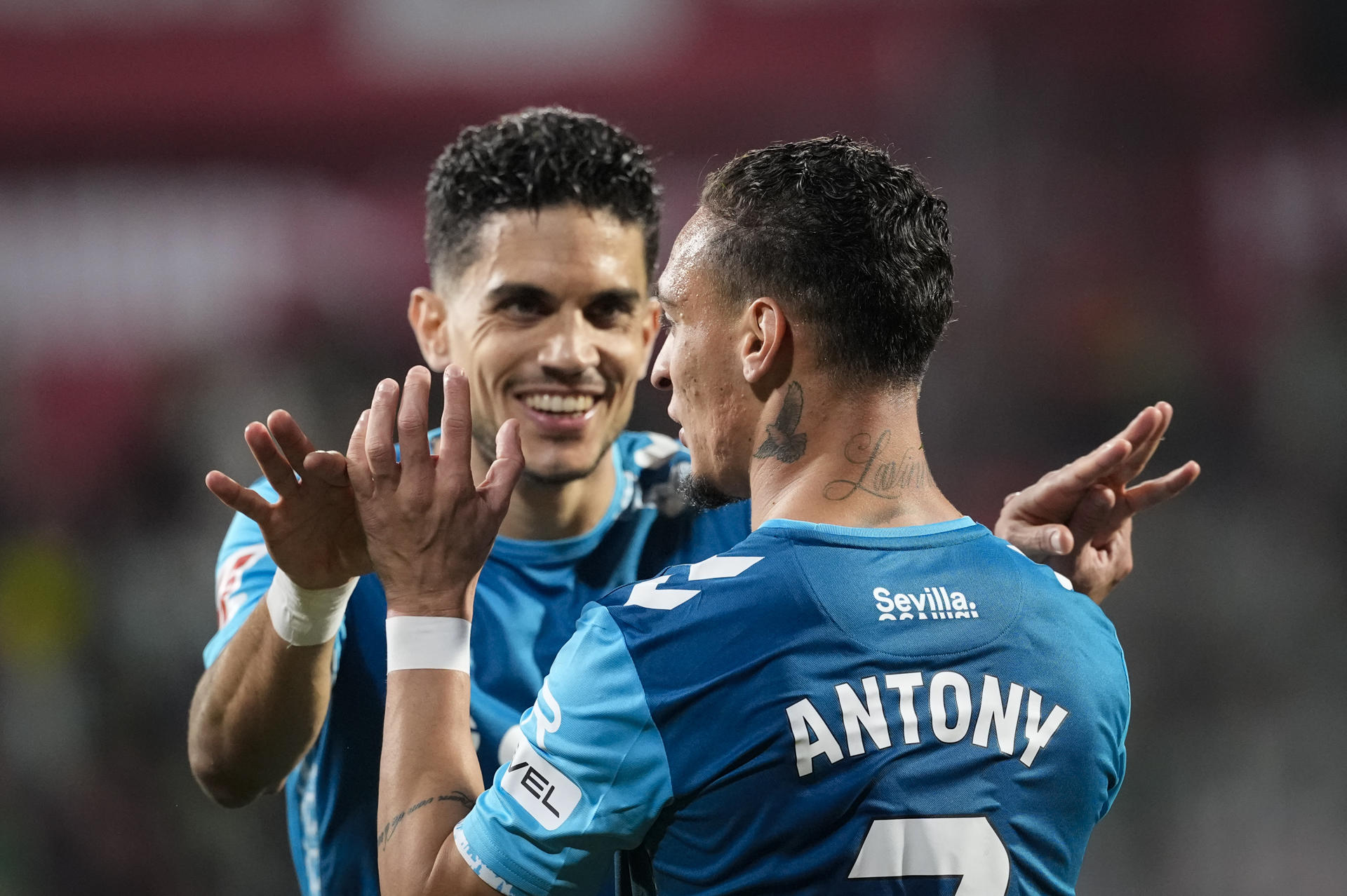 Los jugadores del Betis, el brasileño Antony (d) y Marc Bartra, celebran el segundo gol del equipo bético durante el encuentro correspondiente a la jornada 32 de Laliga EA Sports que disputaron Girona y Betis en el estadio de Montilivi, en Girona. EFE / David Borrat