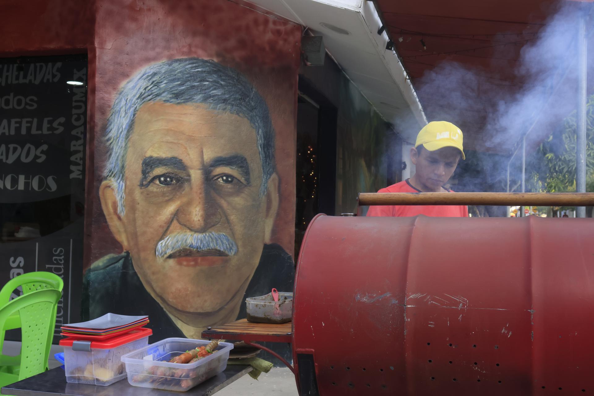 Un hombre cocina frente a un mural con la imagen del escritor Gabriel García Márquez, en Aracataca (Colombia). Foto de archivo. EFE/ Ricardo Maldonado Rozo