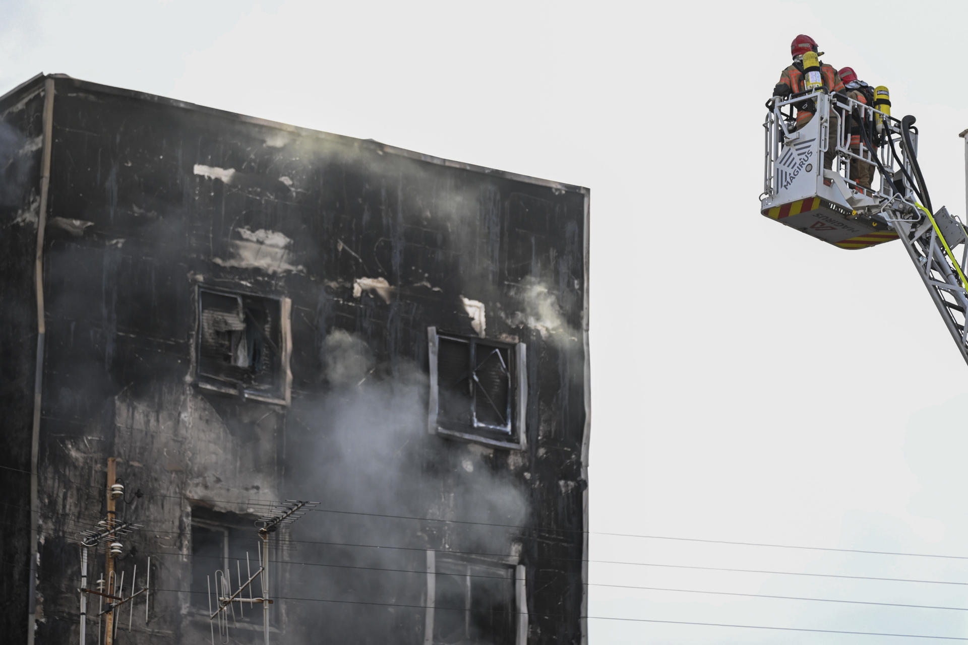 Los bomberos intentan controlar las llamas que afectan este miércoles por la tarde a un edificio en la ciudad de Castellón de la Plana, sin que por el momento haya constancia de personas heridas aunque sí hay varias confinadas. EFE/ Andreu Esteban