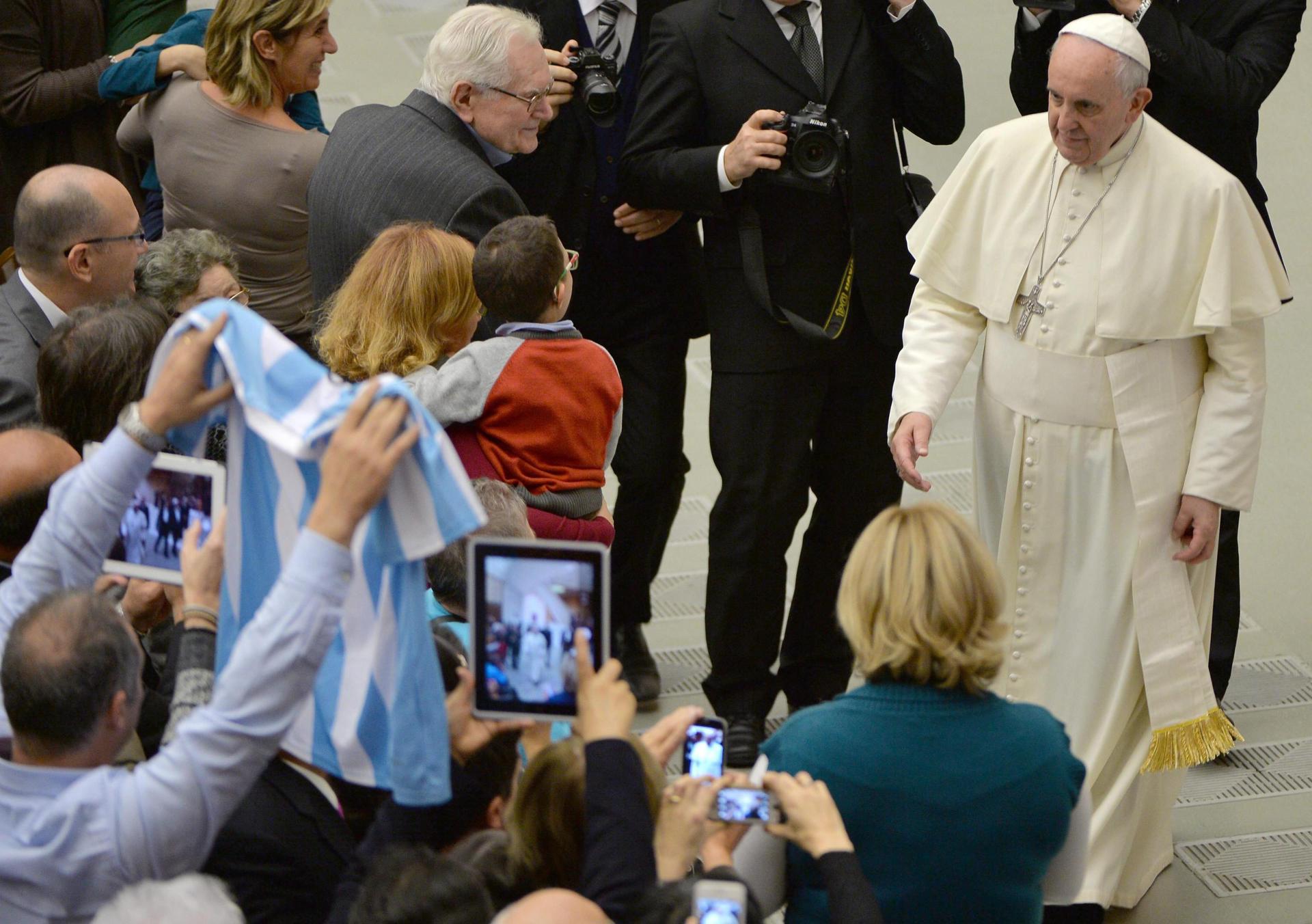 Un voluntario saluda al Papa Francisco (d) mostrando una camiseta de la selección argentina de fútbol en 2014 en foto de archivo de Maurizio Brambatti. EFE