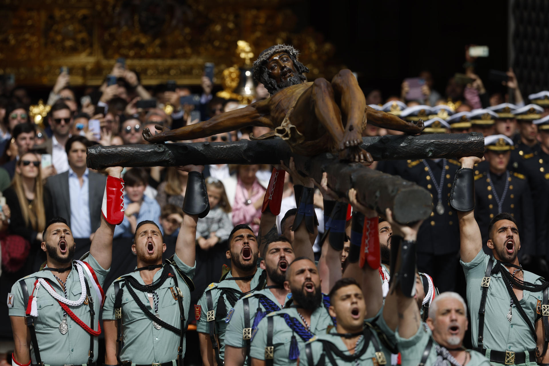 Miembros de la Legión portan el Cristo de la Buena Muerte, de la Cofradía de Mena, por las calles de Málaga este Jueves Santo en uno de los eventos más populares de la Semana Santa andaluza, que congrega a miles de personas. EFE/ Jorge Zapata