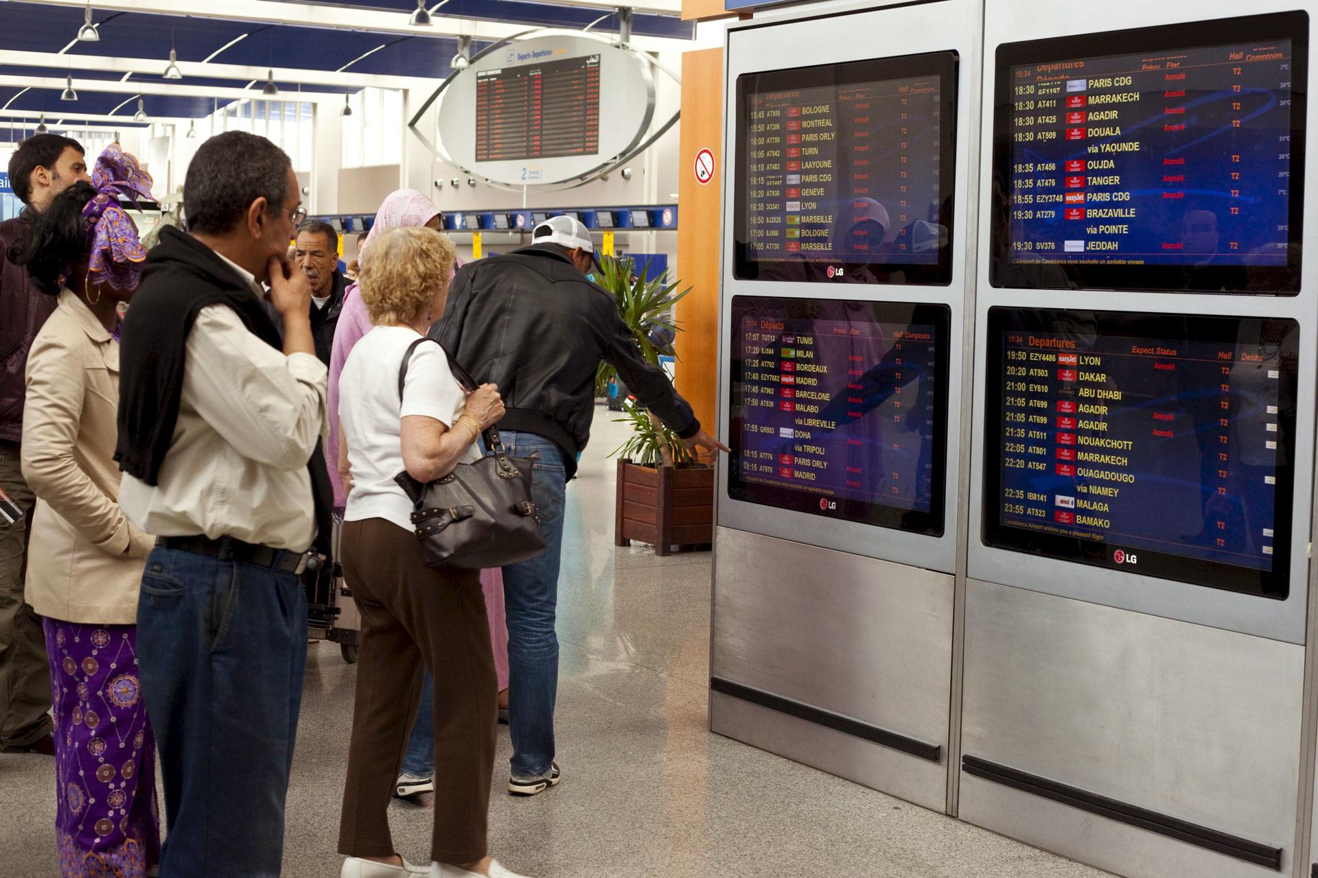 Varios pasajeros observan los paneles informativos que anuncian la cancelación de todos los vuelos en el aeropuerto de Casablanca, Marruecos. EFE/ARCHIVO/Zacarías García
