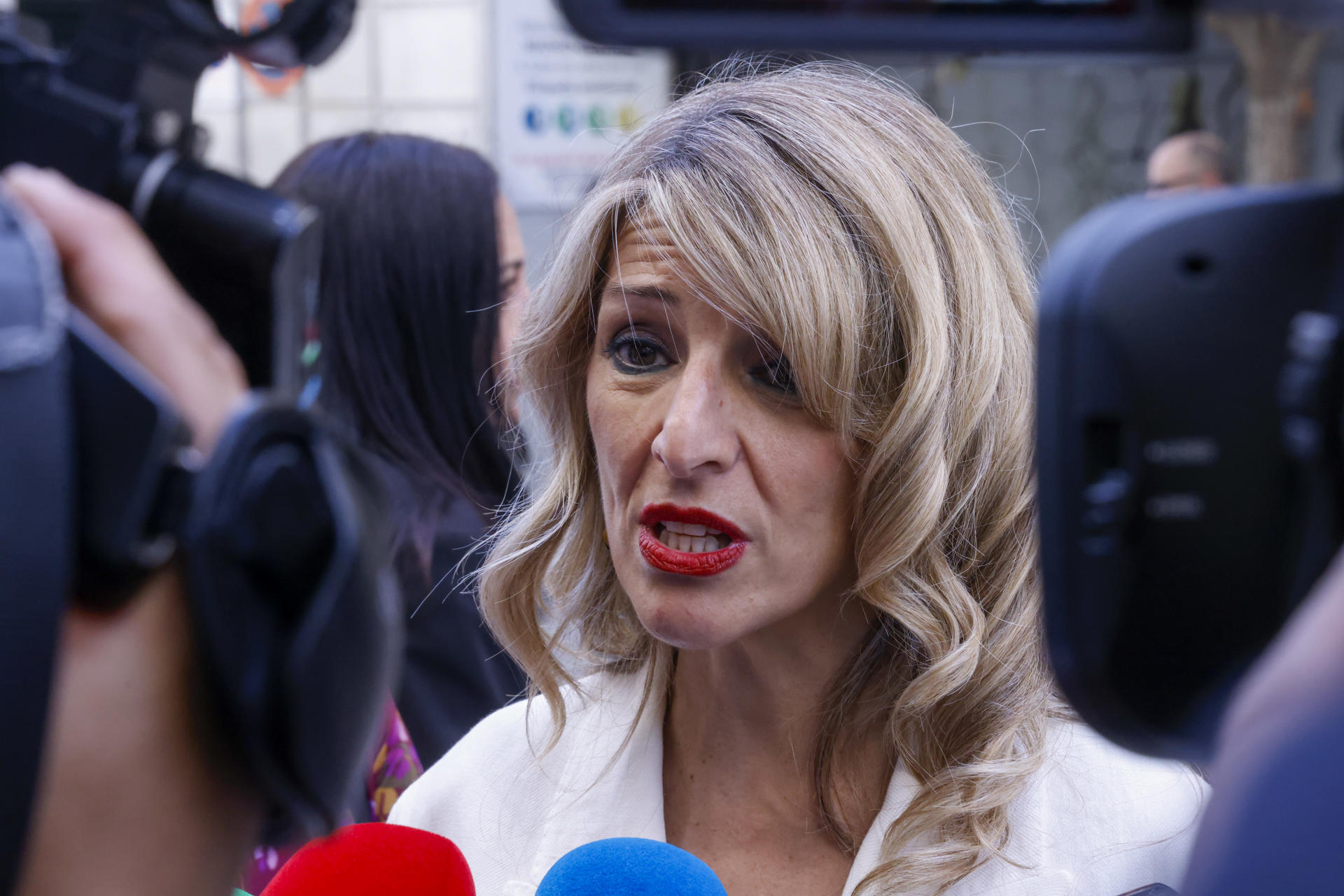 La vicepresidenta segunda y ministra de Trabajo y Economía Social, Yolanda Díaz, atiende a la prensa a su llegada para clausurar el acto de entrega del premio CEDRO al escritor y periodista Manuel Rivas (d), organizado por el Centro Español de Derechos Reprográficos (CEDRO), este viernes en Madrid. EFE/ Blanca Míllez
