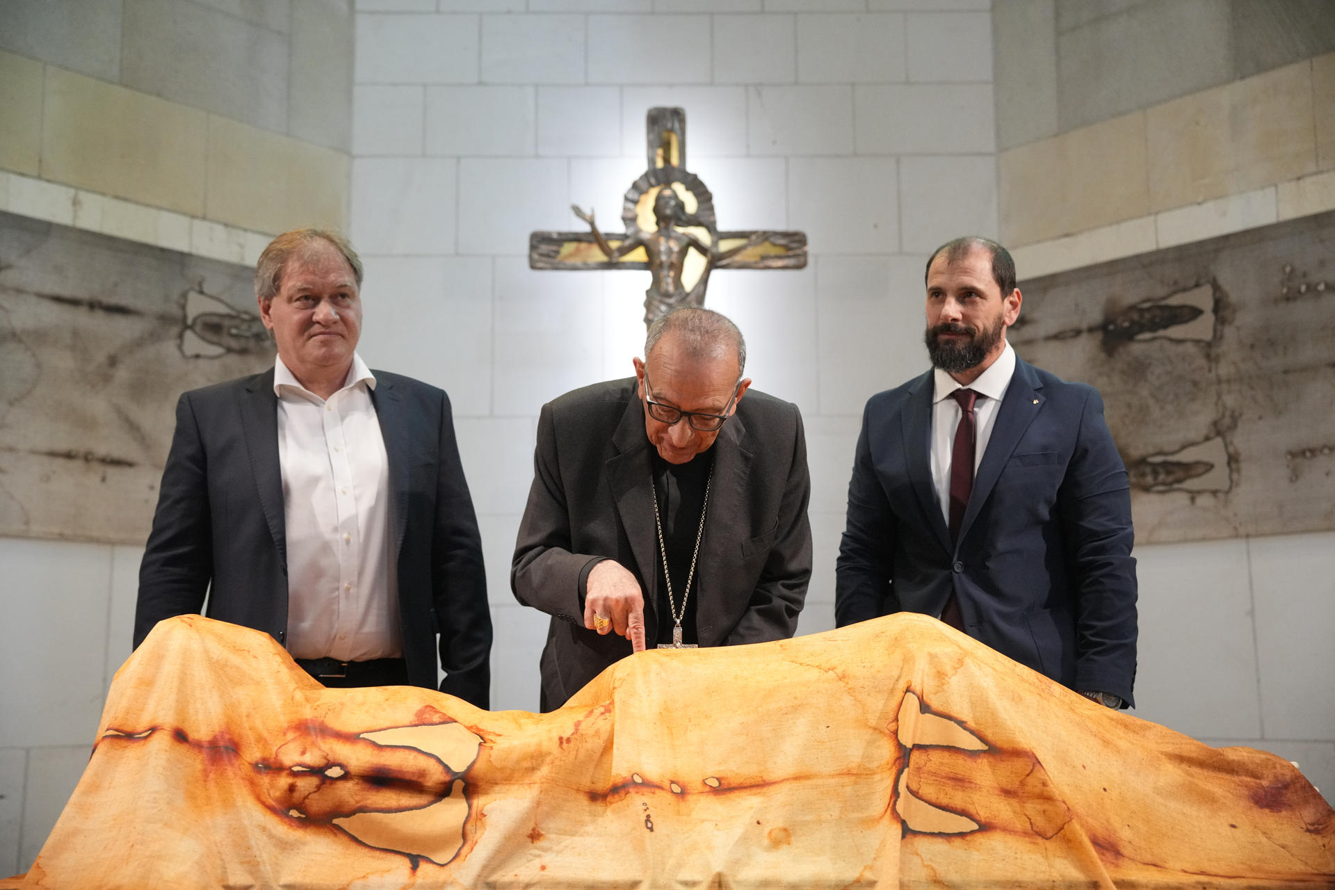 El cardenal arzobispo de Barcelona, Joan Josep Omella, junto a los hijos de los escultores Albano Poli, Paolo Poli (i), y de Sergio Rodella, Enmanuele Rodella (d), durante la presentación de una exposición temporal que se podrá ver hasta diciembre en la Sagrada Familia, en la que se exhibirán las esculturas 'Hombre del Santo Sudario' (Uomo sindónico), de Sergio Rodella, y 'Cruz de la Esperanza' (Cristo della speranza), del maestro Albano Poli. EFE/Alejandro García