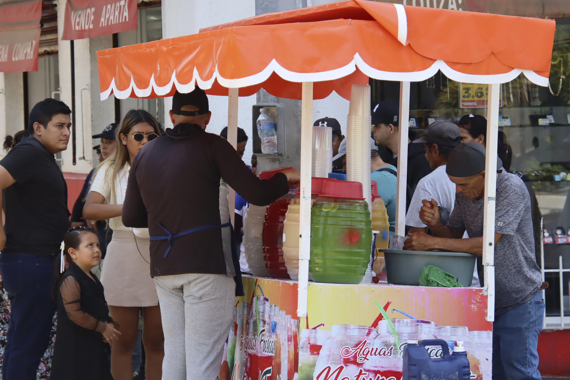 Personas compran agua de sabor para refrescarse este viernes en la ciudad de Tapachula, en Chiapas (México). EFE/ Juan Manuel Blanco
