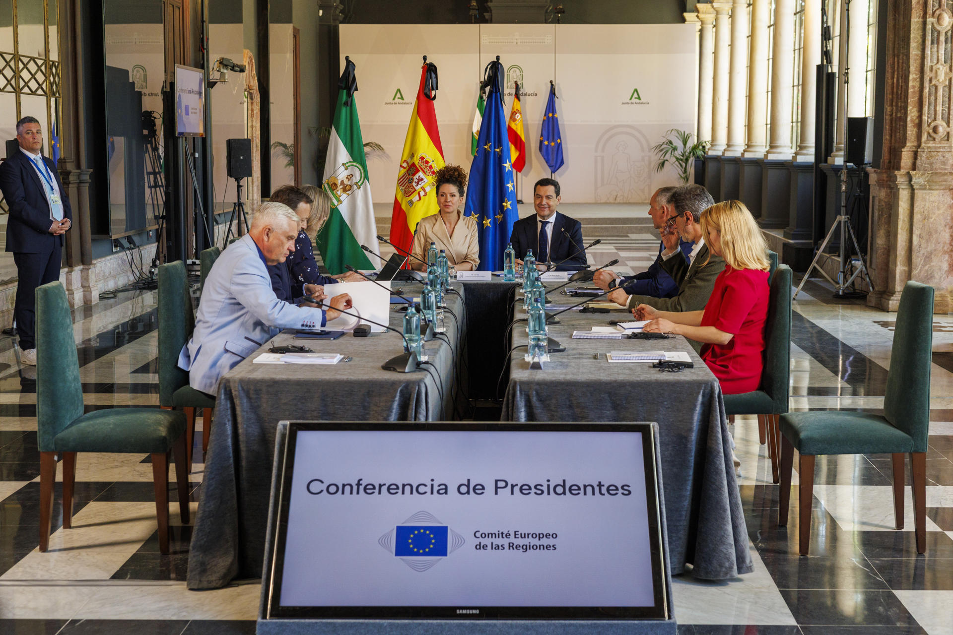 El presidente de la Junta de Andalucía y copresidente del Comité de las Regiones (CdR), Juanma Moreno(cd), junto a la presidenta de este órgano de la Unión Europea, la húngara Kata Tüttö (ci), junto a los integrantes de la Conferencia de Presidentes del CdR al comienzo de la reunión celebrada este miércoles en el Palacio de San Telmo, sede de la presidencia en Sevilla. EFE/ Julio Muñoz