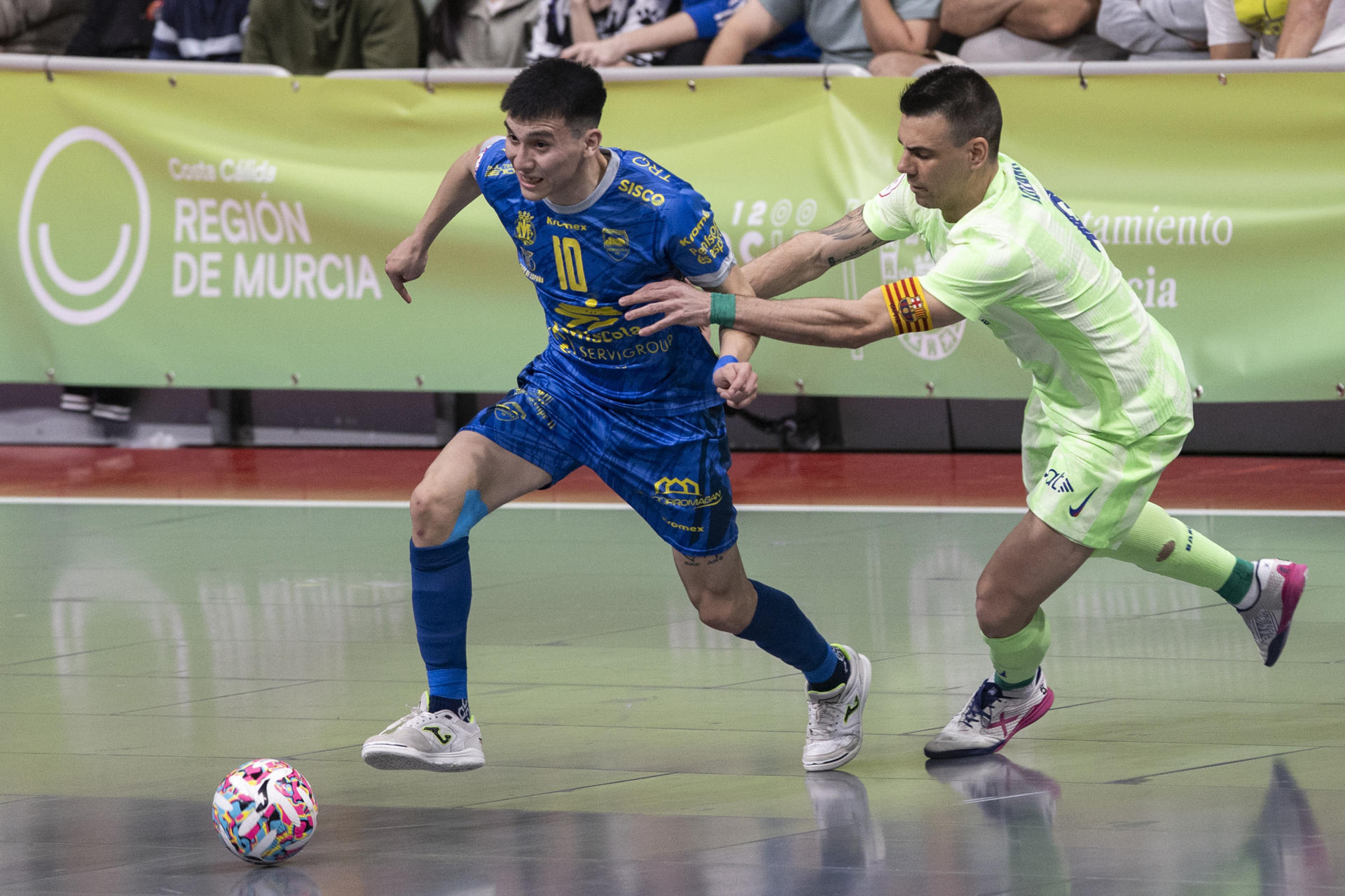 El capitán del Barça Sergio Lozano trata de frenar al jugador de Servigroup Peñiscola Gauna (i), durante el partido que disputaron ambos equipos de las semifinales de la Copa de España de fútbol sala. EFE/Marcial Guillén