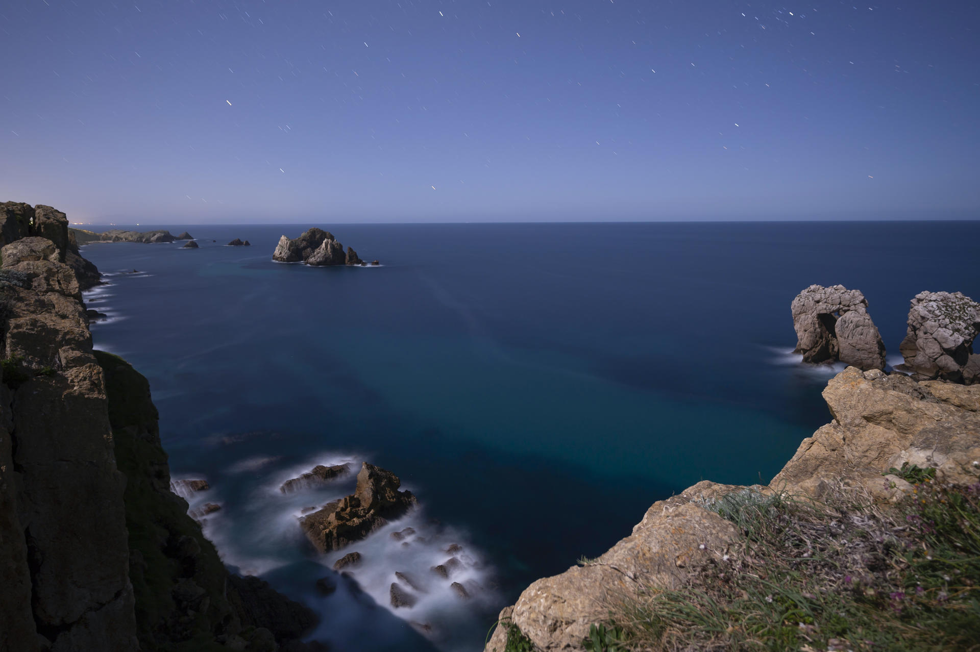 Fotografía de larga exposición que muestra estrellas sobre la conocida como "Puerta del Cantábrico" en el Geoparque de la Costa Quebrada de la localidad cántabra de Liencres. EFE/Pedro Puente Hoyos/Archivo