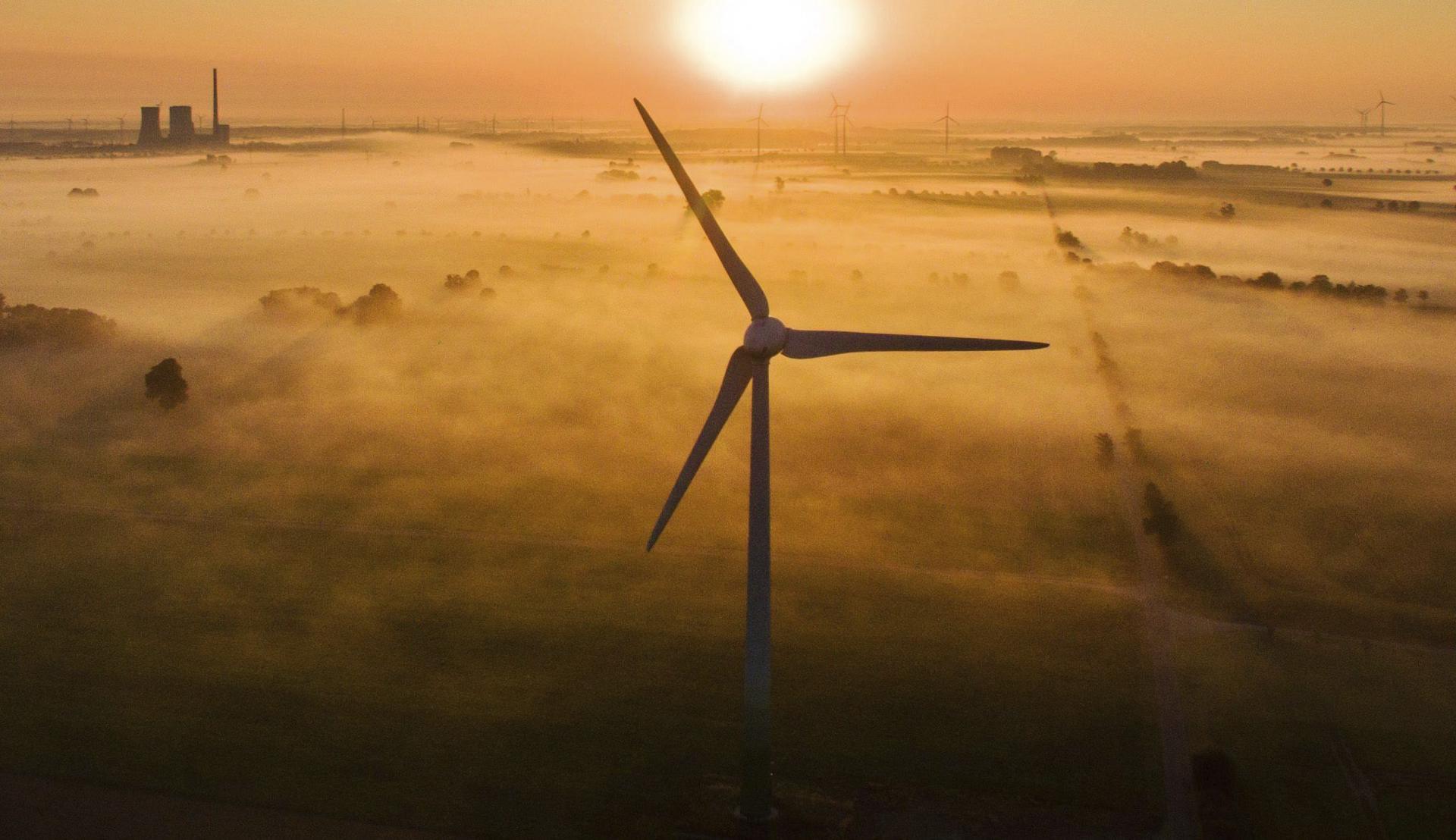 La neblina matutina iluminada por el sol al amanecer sobre una planta eólica en una imagen de archivo. EFE/Julian Stratenschulte