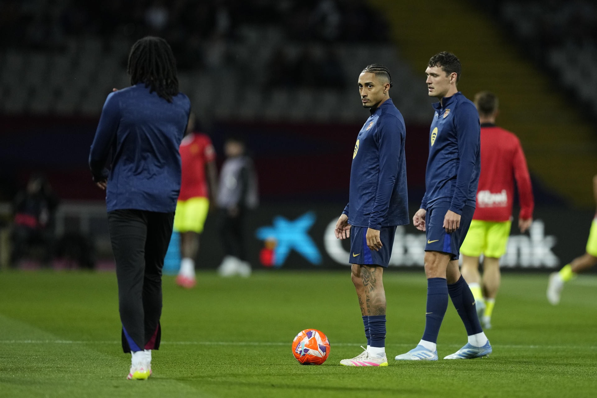 Los jugadores del FC Barcelona, el brasileño Raphinha (c) y el danés Andreas Christensen (d), antes de comenzar el partido de la jornada 33 de LaLiga que FC Barcelona y RCD Mallorca disputan en el Estadi Olímpic Lluís Companys, en Barcelona. EFE/Enric Fontcuberta.
